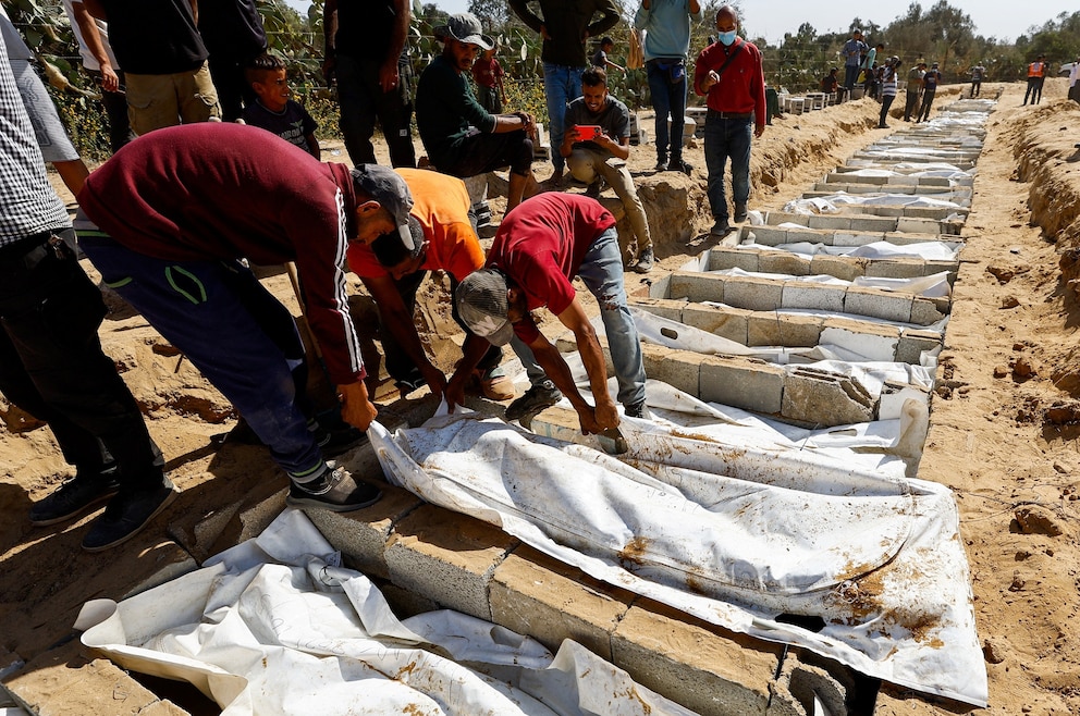 PHOTO: People bury at a mass burial site unidentified bodies of Palestinians who had been held in Israel during the war, after they were handed over by Israel, amid a ceasefire between Israel and Hamas in Gaza, in Deir Al-Balah, Oct. 22, 2025. 