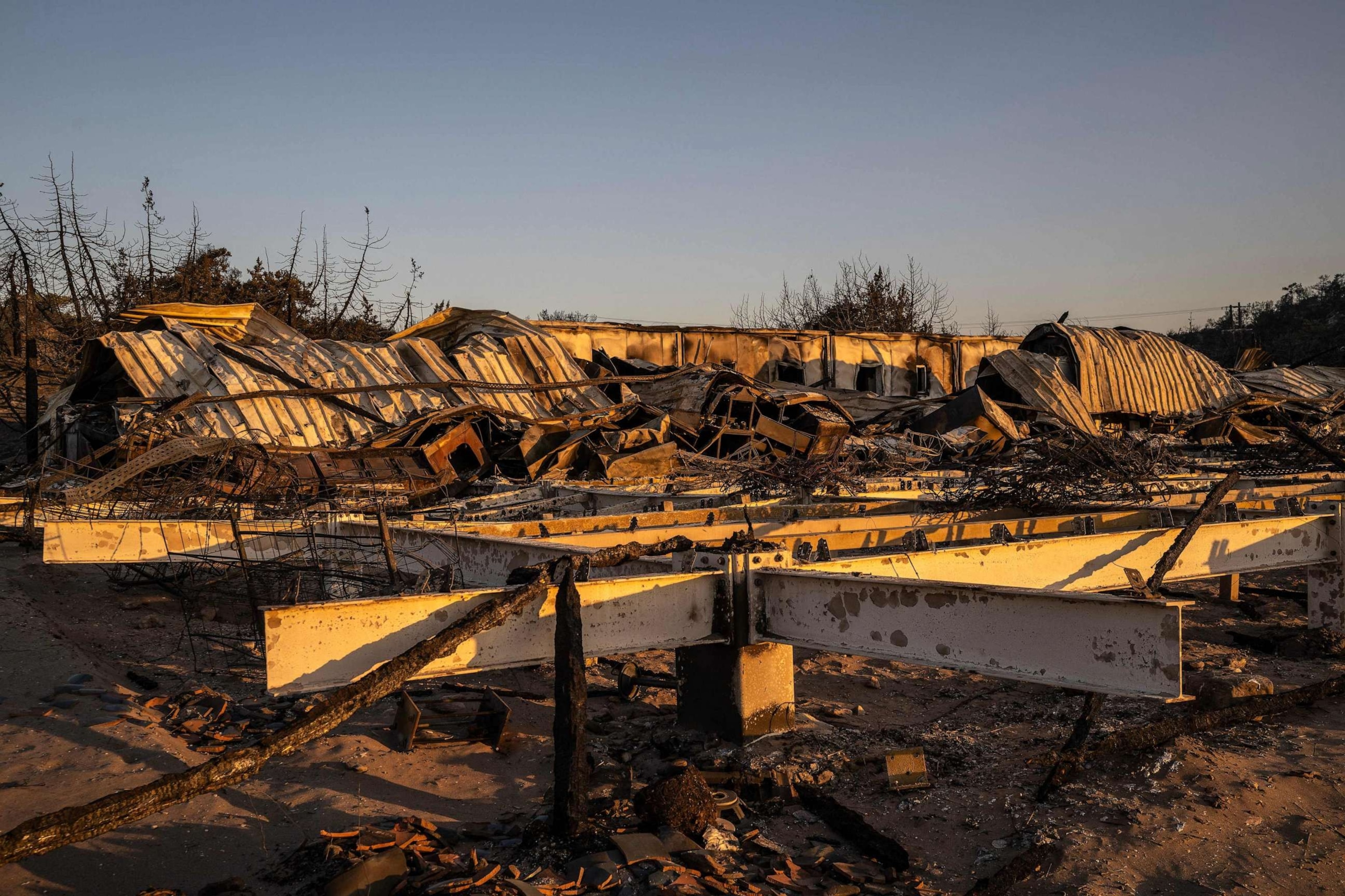 PHOTO: A beach bars destroyed by wildfires lies crumples at the beach of Glystra, along the coast from Kiotari on the Greek island of Rhodes, on July 25, 2023.