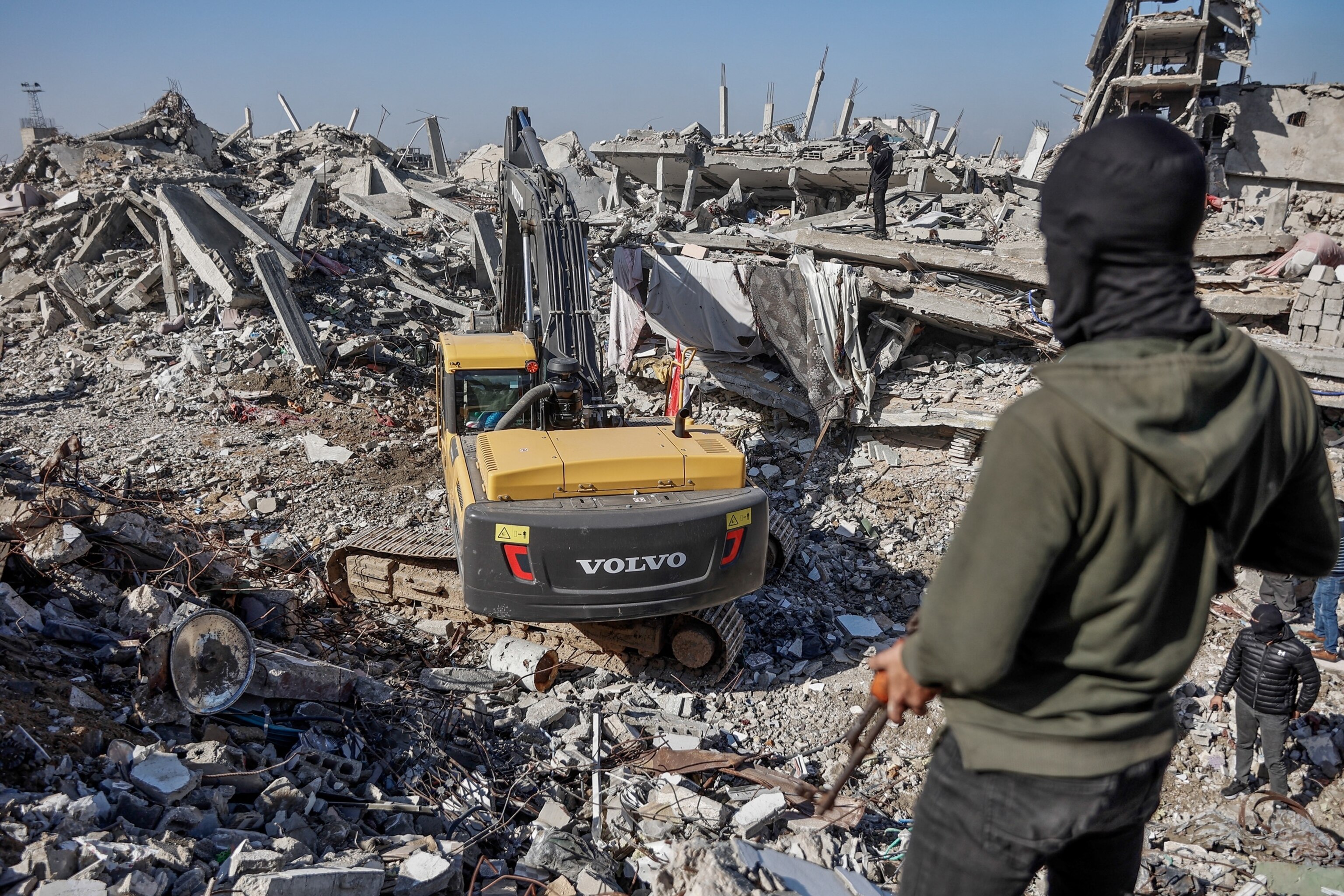 PHOTO: A Palestinian Hamas militant looks on as Egyptian workers accompanied by members of the International Committee of the Red Cross use a digger as they search for the last two remaining bodies of hostages in northern Gaza on Dec. 1, 2025.