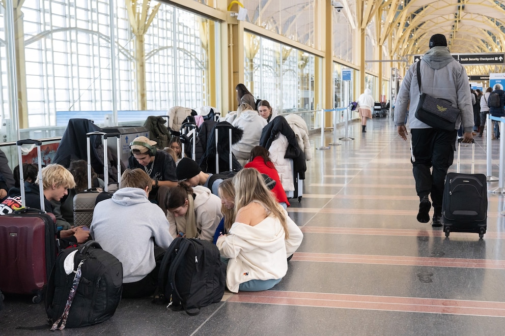 PHOTO: People sit and wait at Ronald Reagan Washington National Airport  as flights are delayed and cancelled following a significant winter storm in Arlington, Virginia, January 26, 2026.