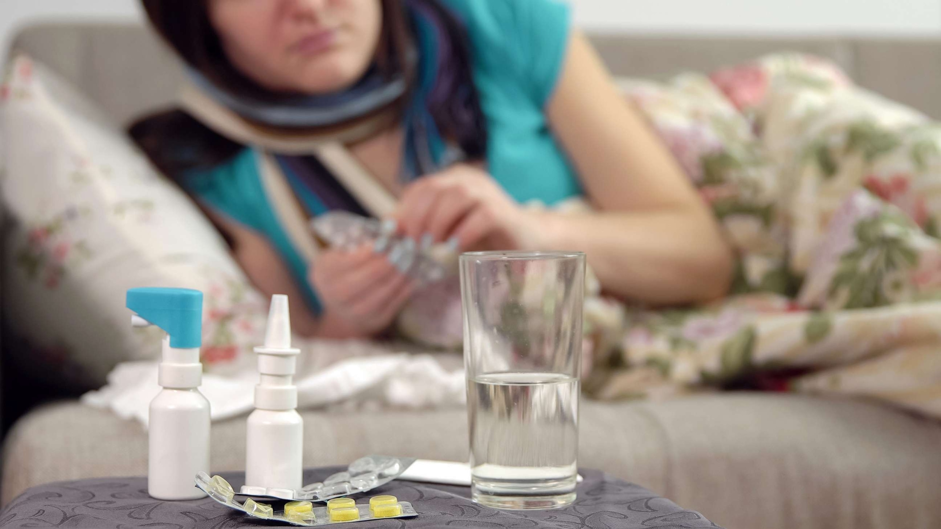 PHOTO: A stock photo shows a sick person with tablets, nasal spray and other medicines, along with a glass of water.