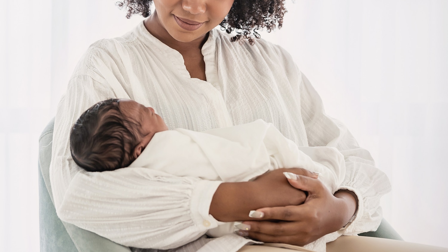 A Black new mom holding a newborn child
