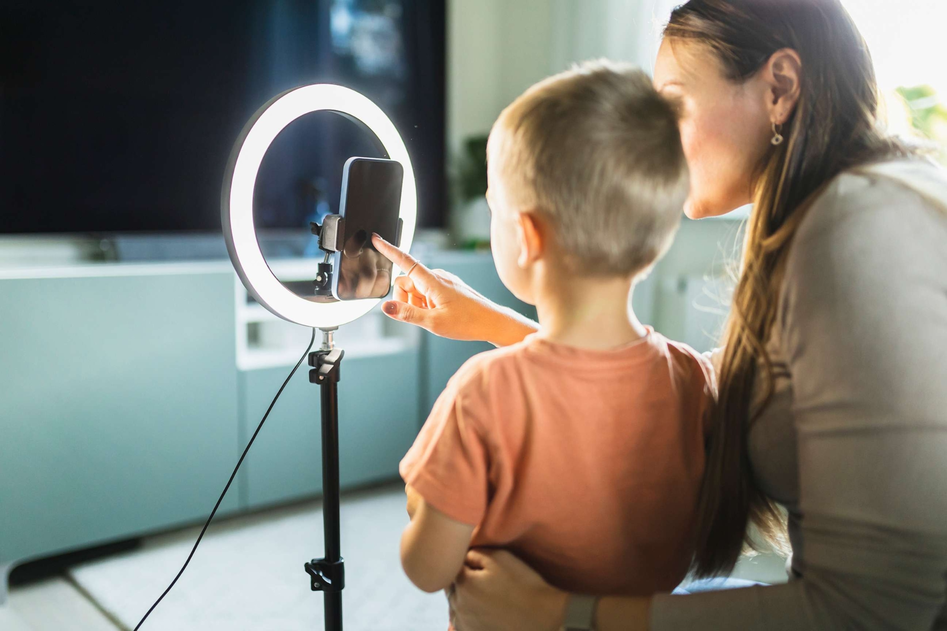 PHOTO: A stock photo shows a mother setting up a ring light and a mobile phone for live streaming with her son.