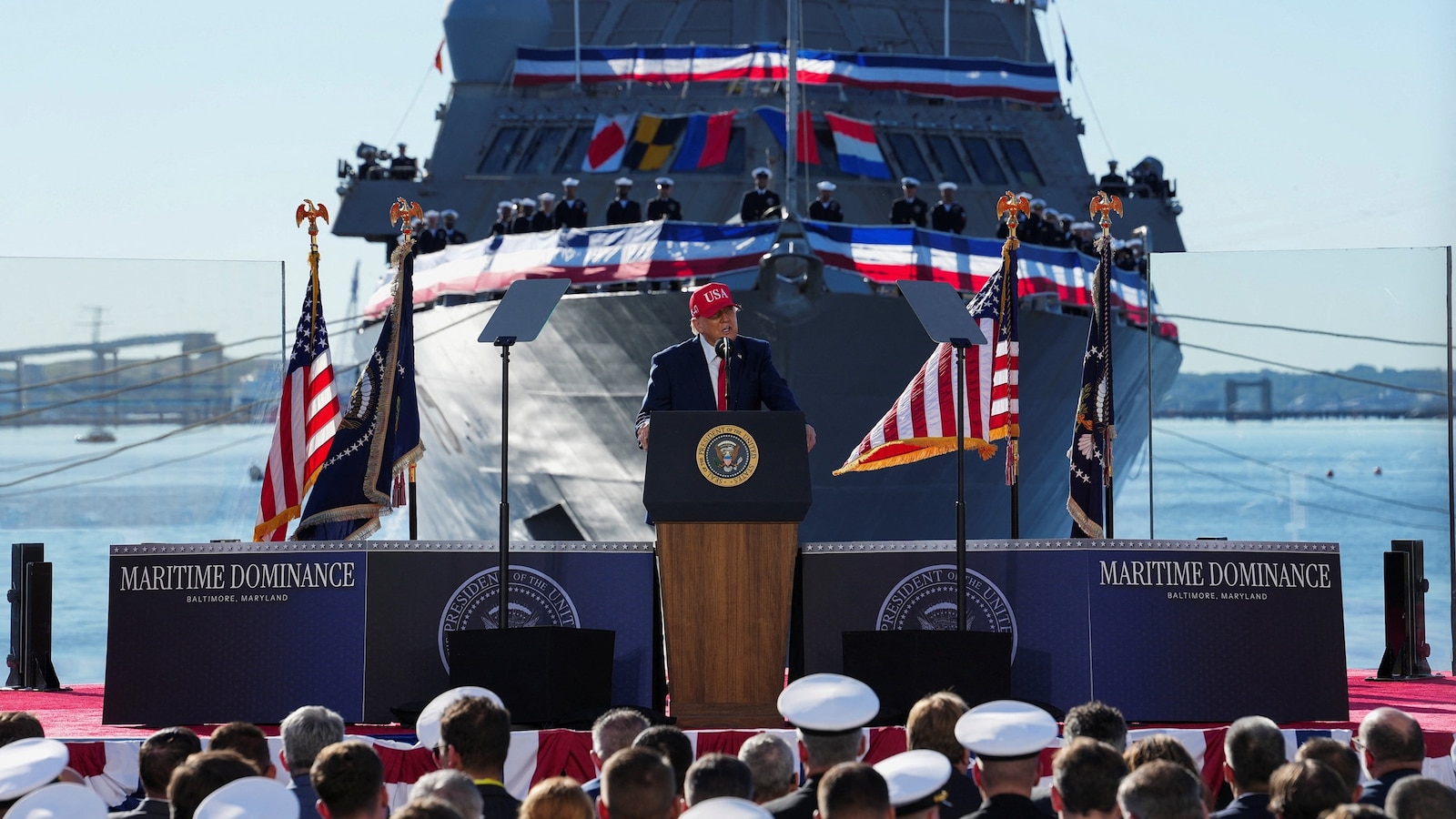 US Navy members listen to US President Donald Trump speak during an event at Sparrows Point Shipyard, as the USS Billings sits in the background, in Baltimore County, Maryland, October 6, 2026.