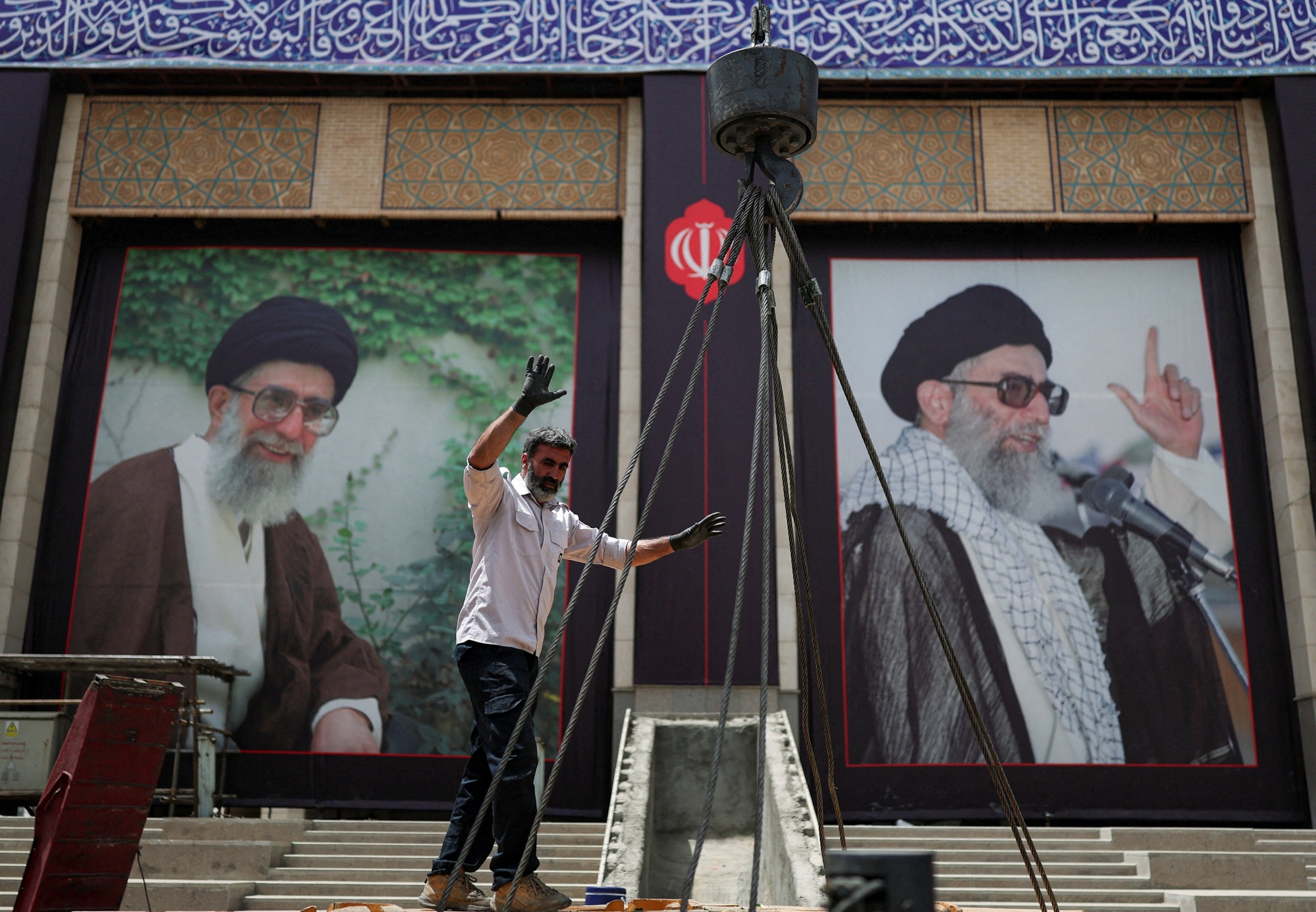 PHOTO: A man gestures next to crane cables as preparations are underway ahead of a farewell ceremony for Iran's late Supreme Leader Ayatollah Ali Khamenei, at the Imam Khomeini Grand Mosalla, in Tehran, Iran July 2, 2026. 