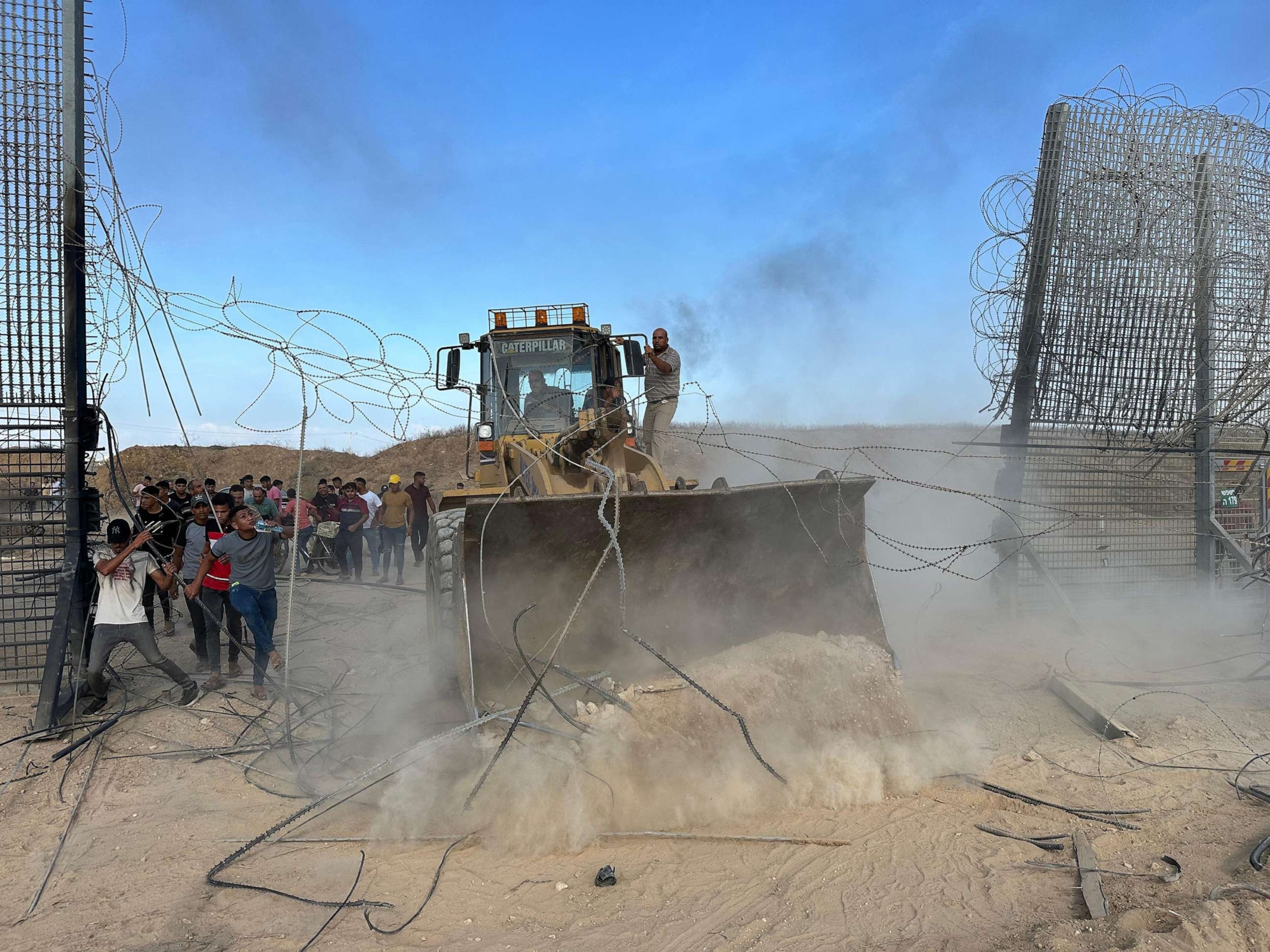 PHOTO: Palestinians cross the border fence with Israel from Khan Yunis in the southern Gaza Strip, on Oct. 7, 2023.