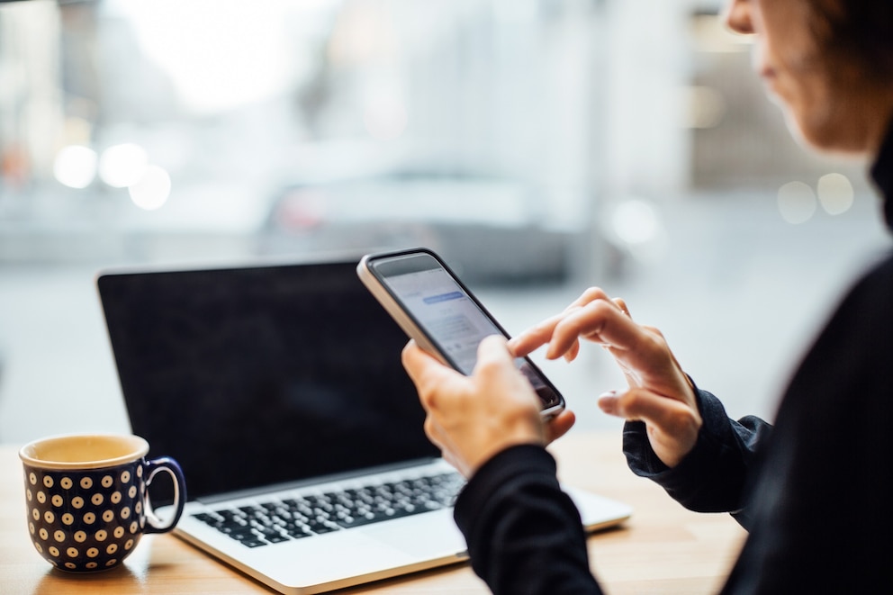 PHOTO: Woman texting on smart phone at cafe
