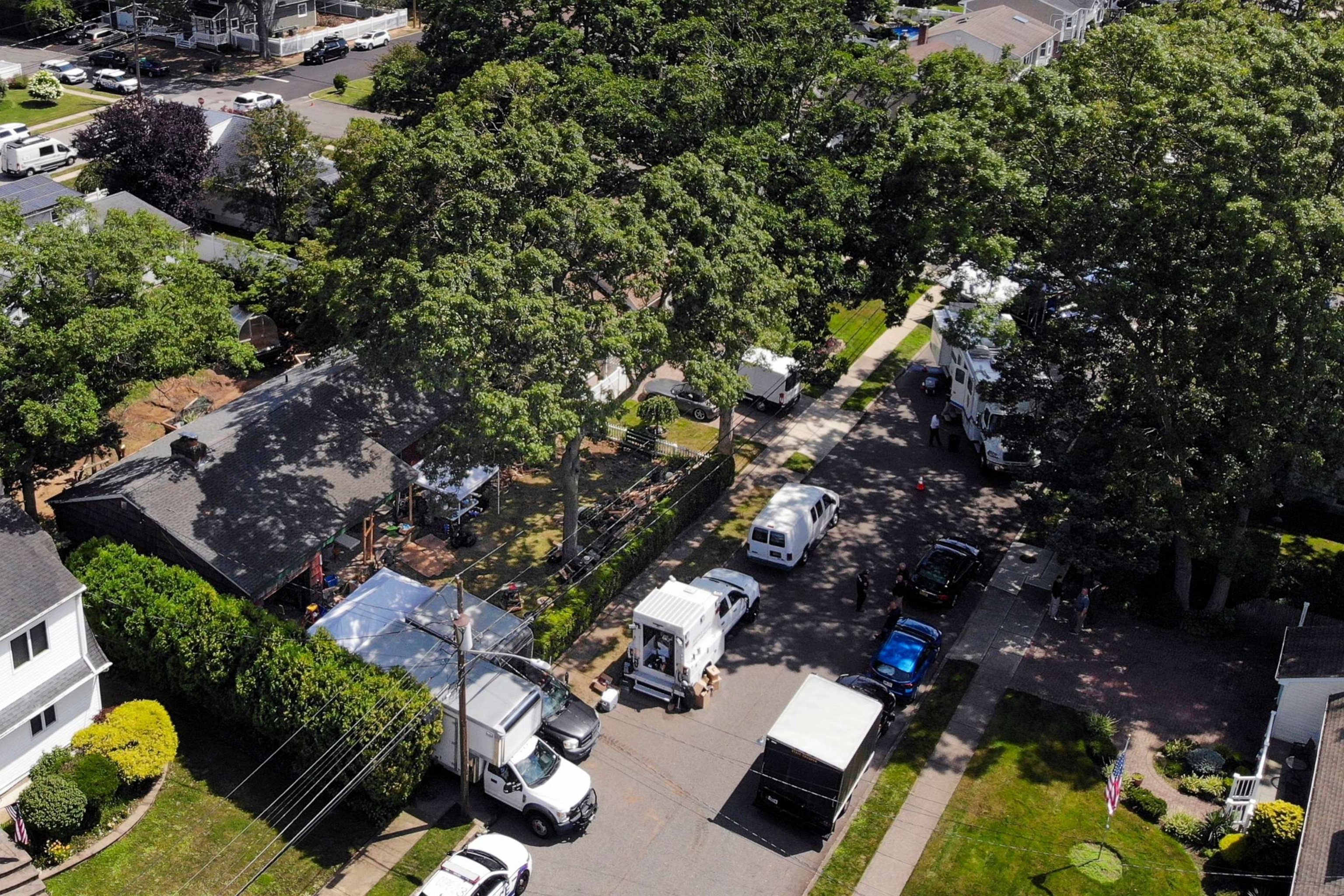 PHOTO: Authorities work at the home of suspect Rex Heuermann, left, in Massapequa Park, N.Y., July 24, 2023.