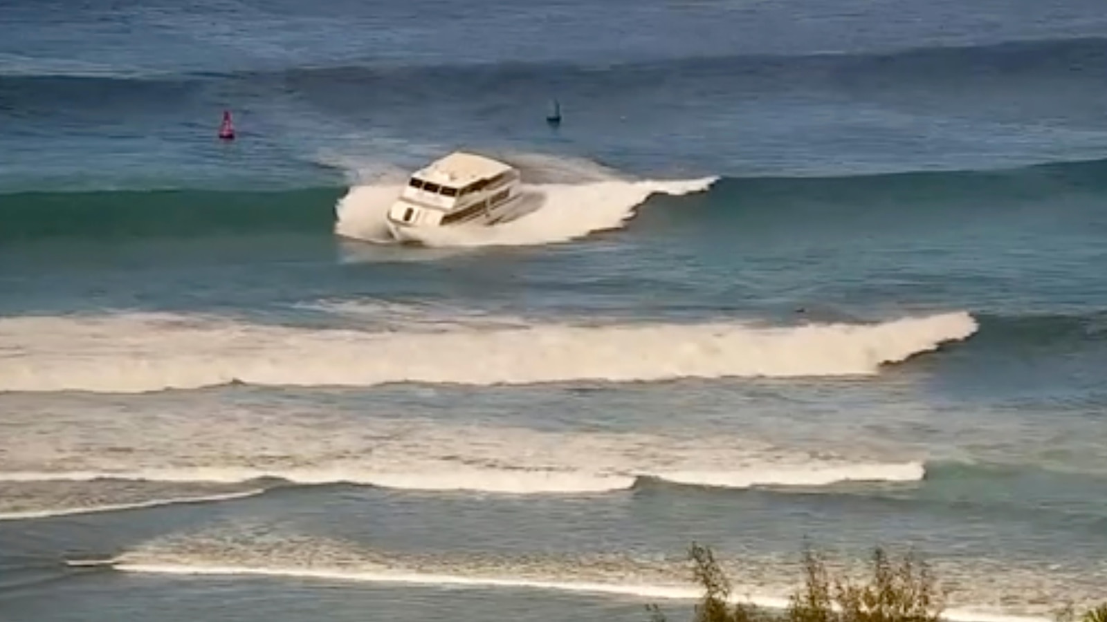 Yacht-sized passenger boat runs aground in high surf off Hawaii beach