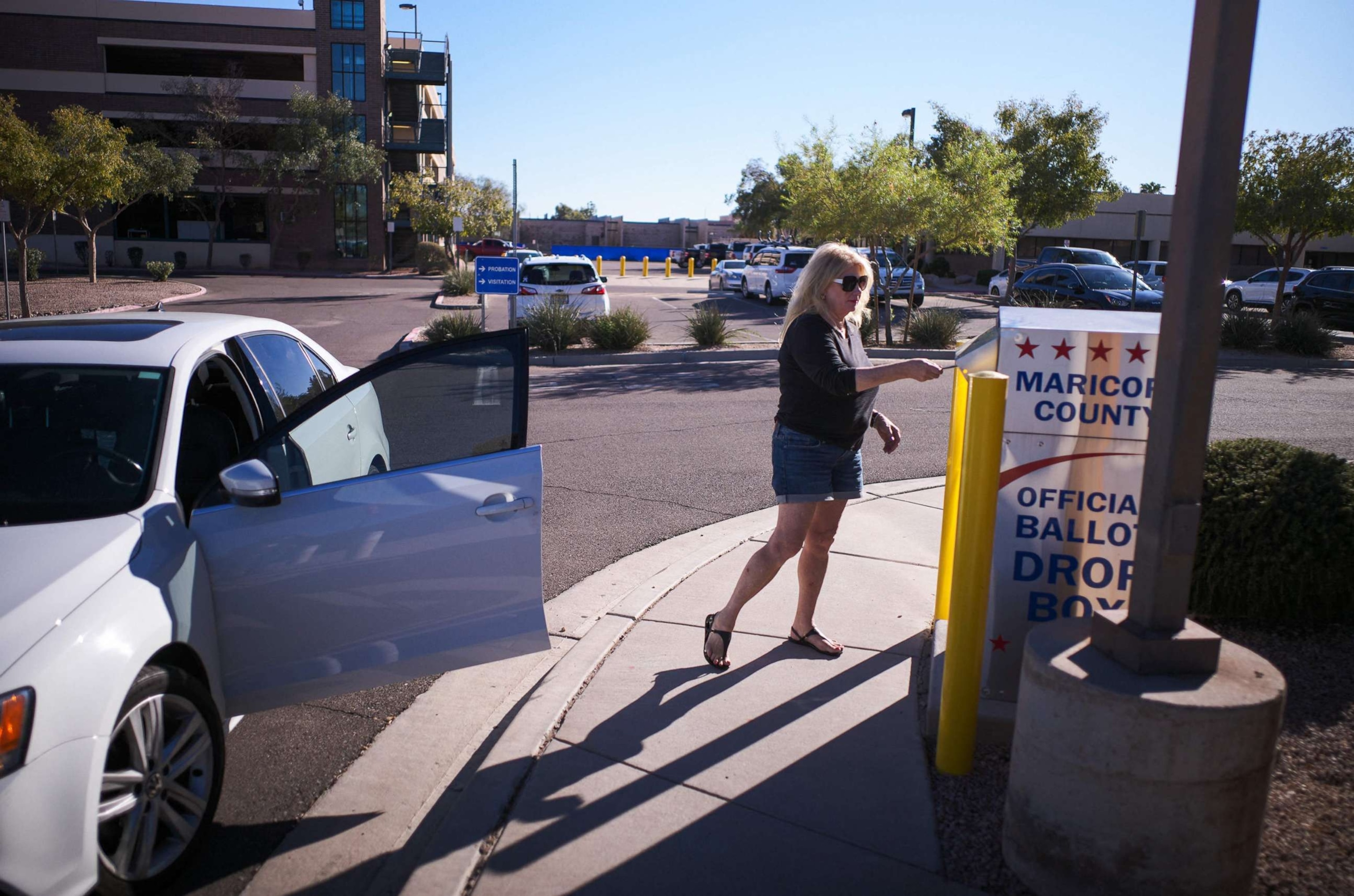 PHOTO: A woman drops her ballot for the upcoming midterm elections in the drop box near the Maricopa County Juvenile Court Center in Mesa, Arizona, on Oct. 25, 2022.