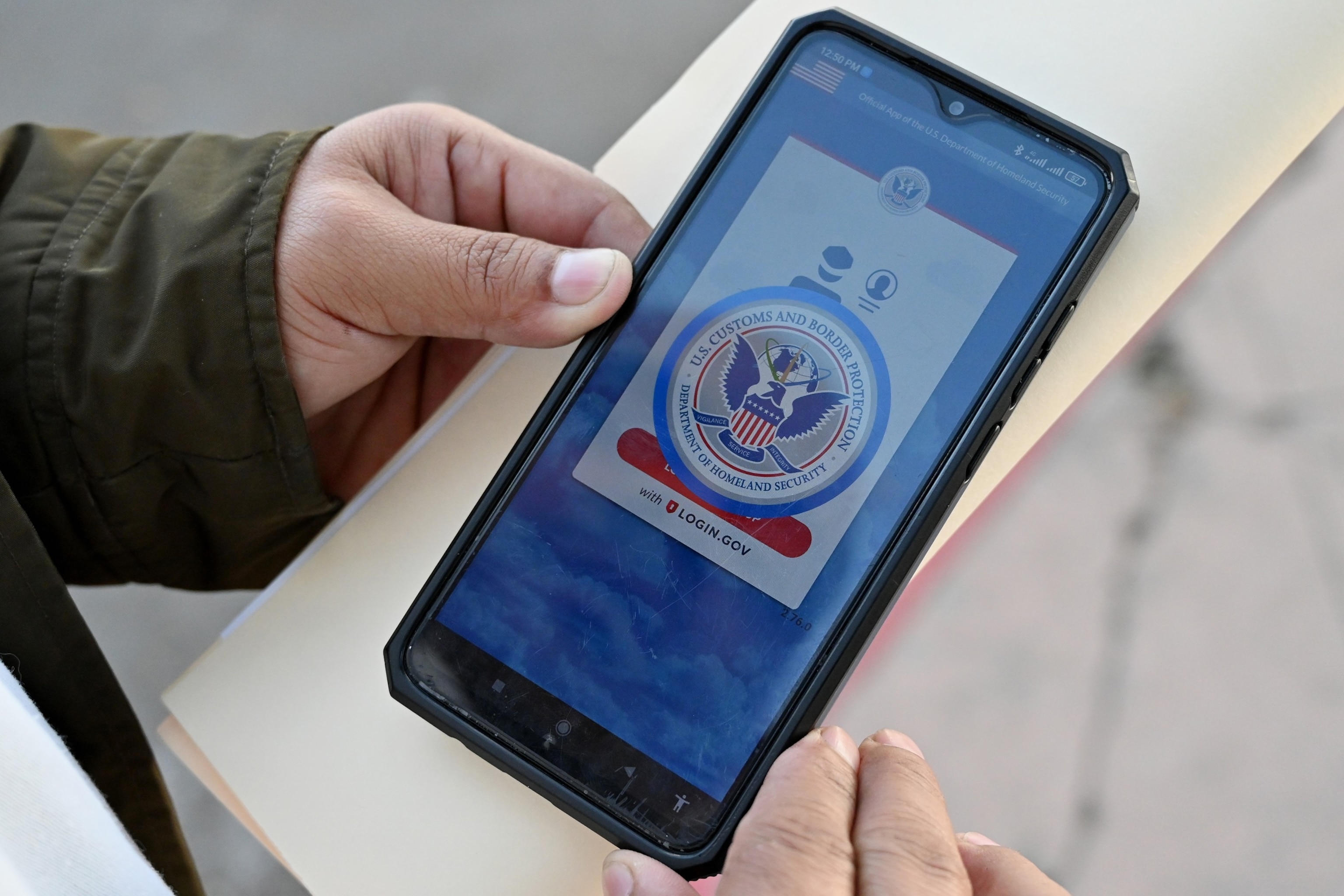 PHOTO: A Mexican immigration official to check his documents as he reviews the CBP One app at the El Chaparral border crossing port in Tijuana, Mexico, Jan. 17, 2025.