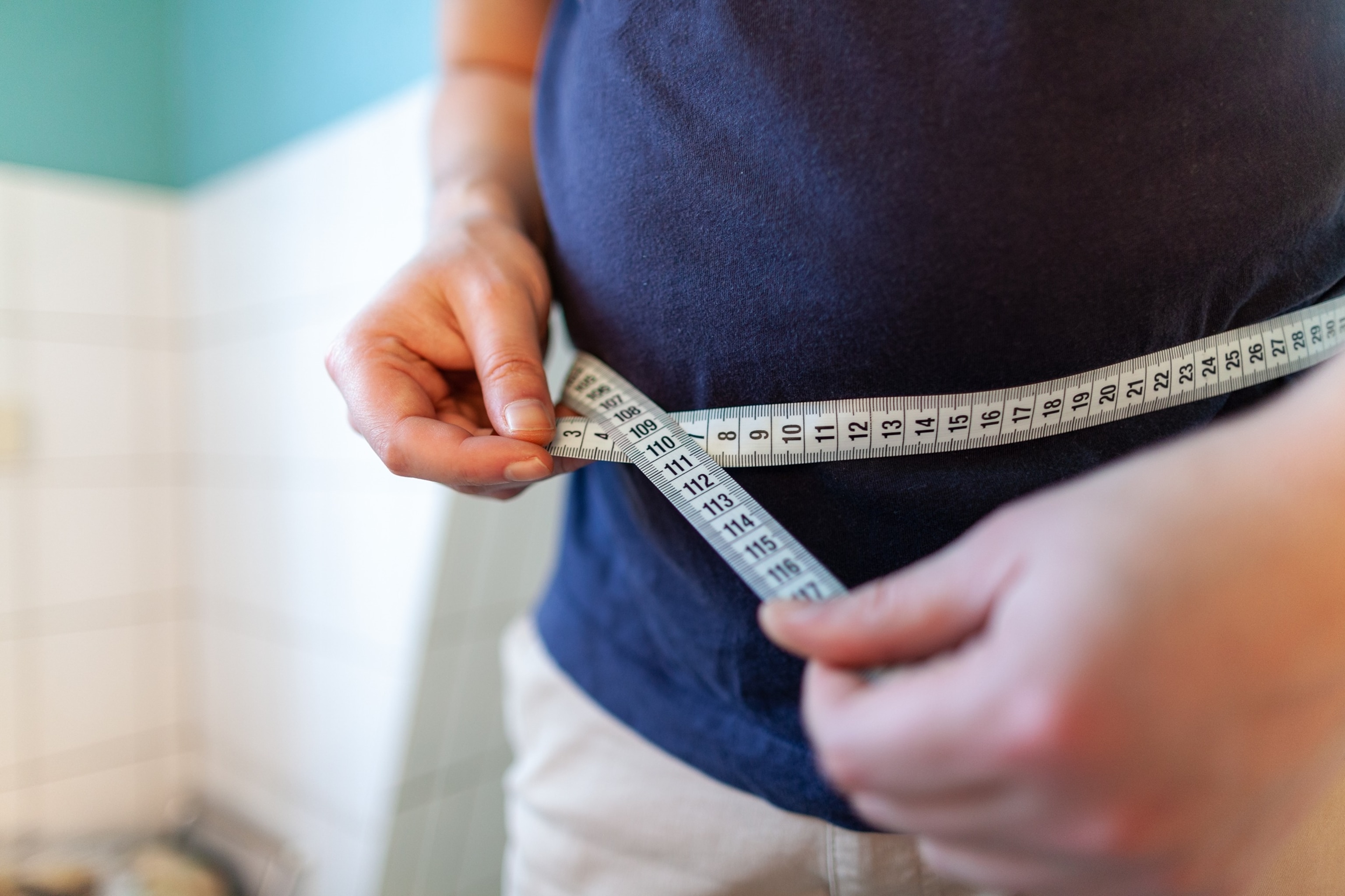 PHOTO: An overweight person measures their waist in an undated stock photo. 
