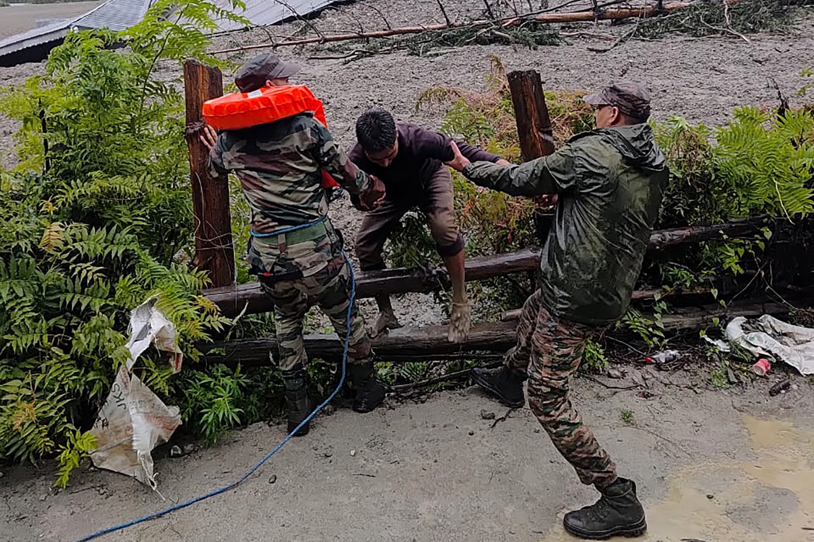 PHOTO: This handout photograph taken on Aug. 5, 2025, and released by the Indian Army shows security personnel rescuing a local resident from dense sludge in India's Uttarakhand state.