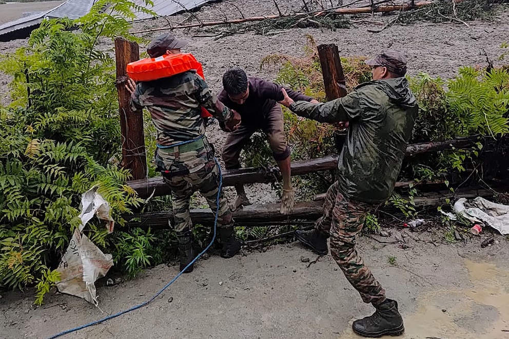 PHOTO: This handout photograph taken on Aug. 5, 2025, and released by the Indian Army shows security personnel rescuing a local resident from dense sludge in India's Uttarakhand state.