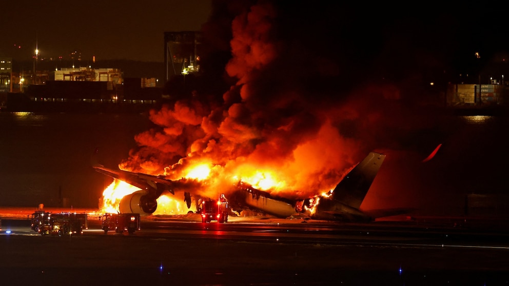 Japan Airlines plane bursts into flames at Tokyo airport with 379 people on board