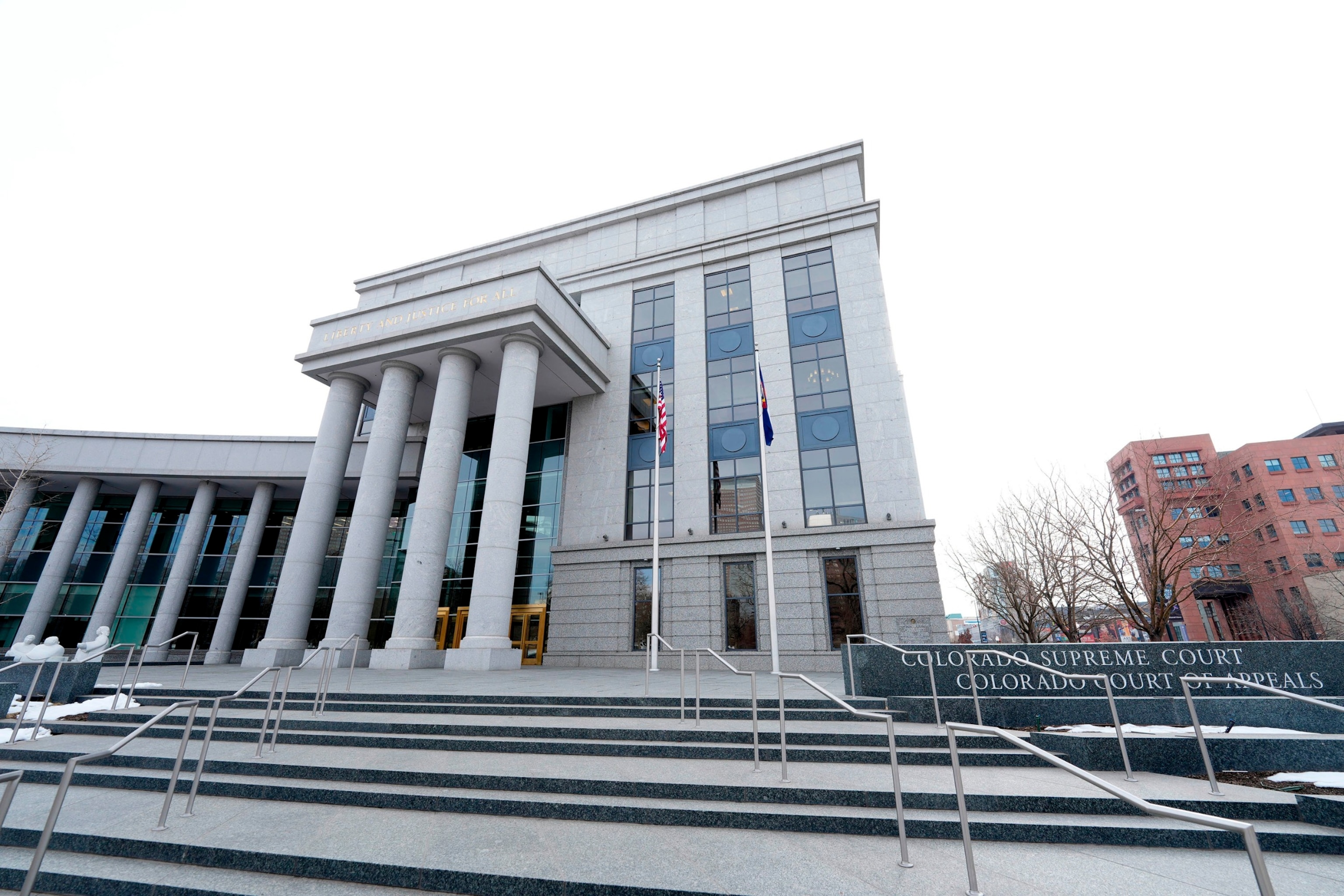 PHOTO: In this Jan. 17, 2023, file photo, flags stand outside the Colorado Supreme Court, in Denver.