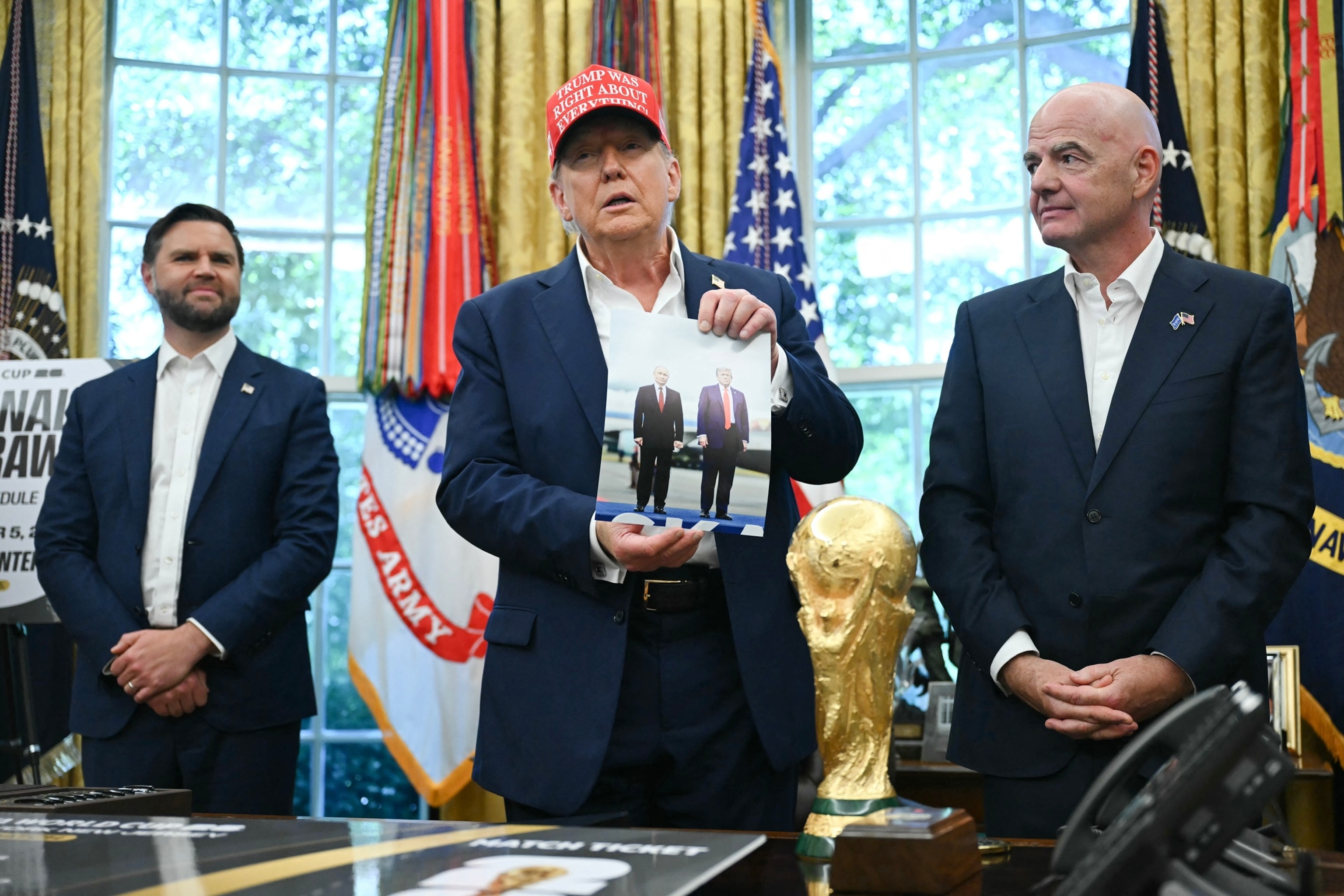 PHOTO: President Donald Trump holds a photograph of him with Russian President Vladimir Putin in Alaska as he speaks in the Oval Office of the White House in Washington, August 22, 2025.