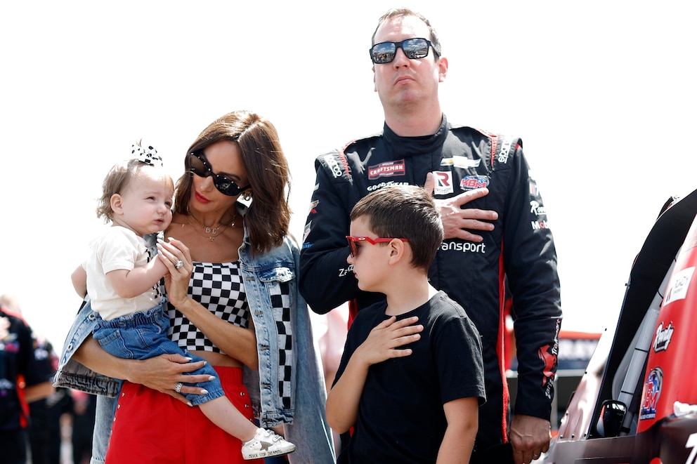 PHOTO: Kyle Busch, driver of the #51 Zariz Transport Chevrolet, stands on the grid during the national anthem with his wife, Samantha Busch, daughter, Lennix Busch and son, Brexton Busch on the grid on July 22, 2023 in Long Pond, Pennsylvania. 