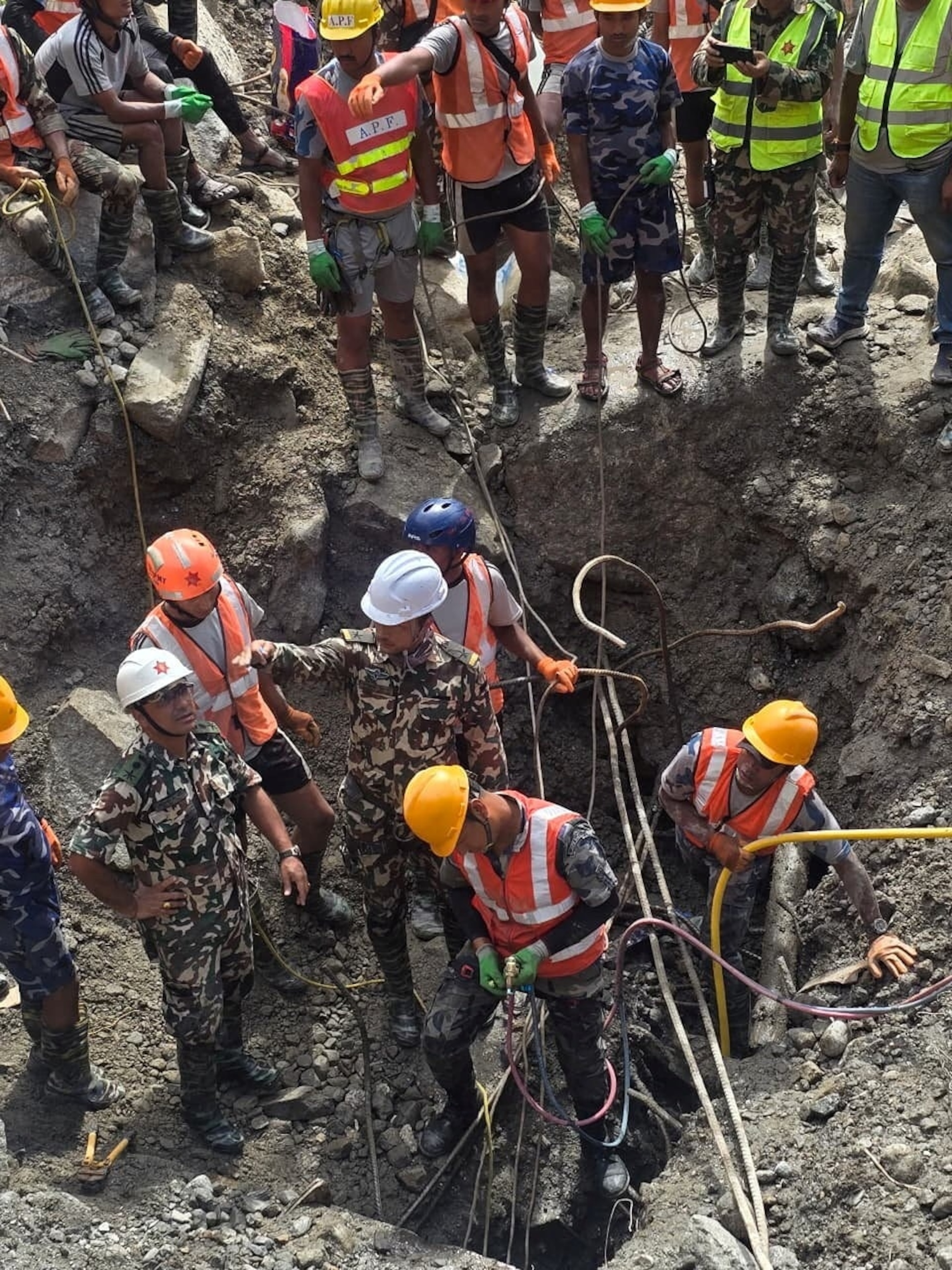 PHOTO: Members of a search and rescue team work to remove the body of a person who was trapped inside a tunnel at the Upper Trishuli-3A Hydropower Project