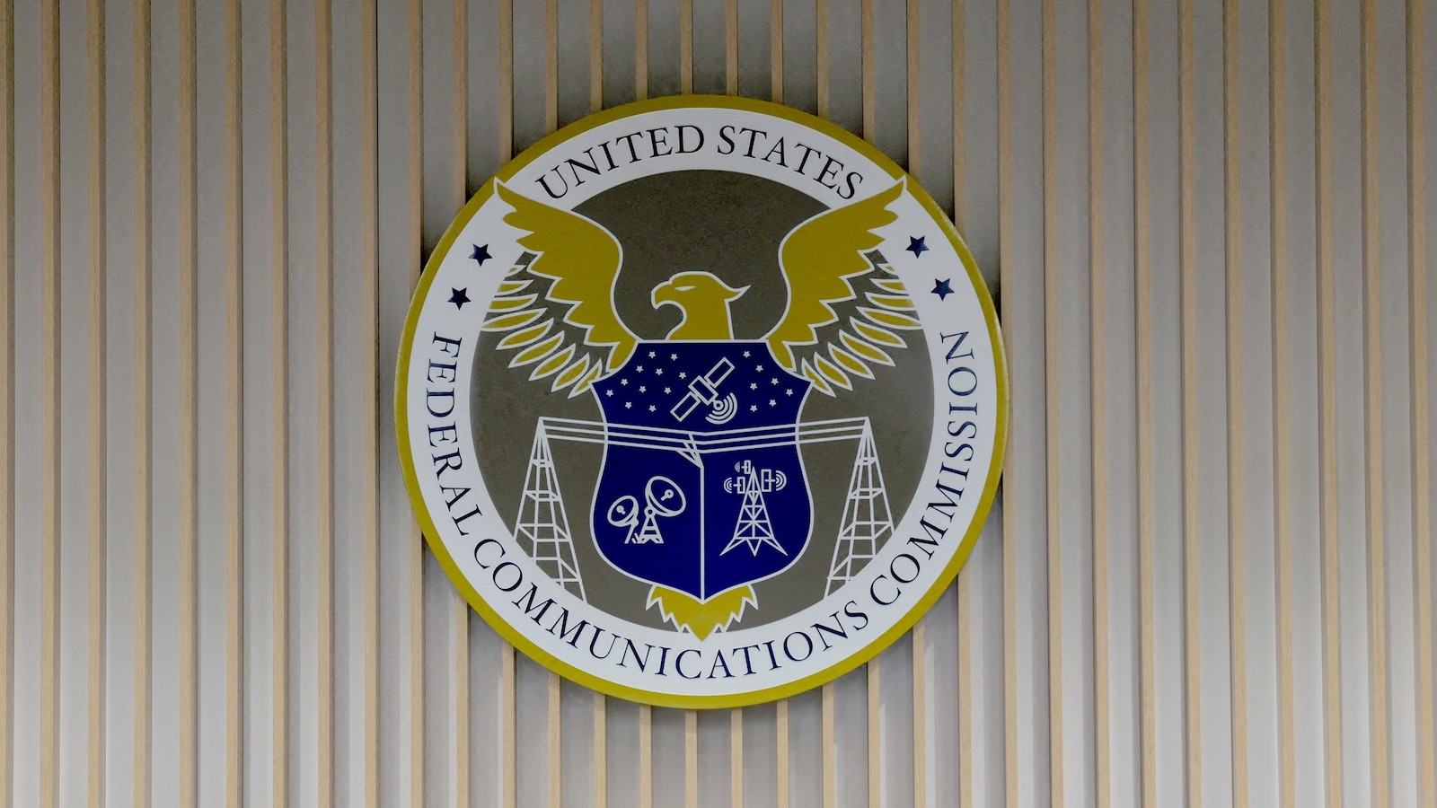 The U.S. Federal Communications Commission logo hangs on a wall during a meeting of the FCC in Washington, July 22, 2026.