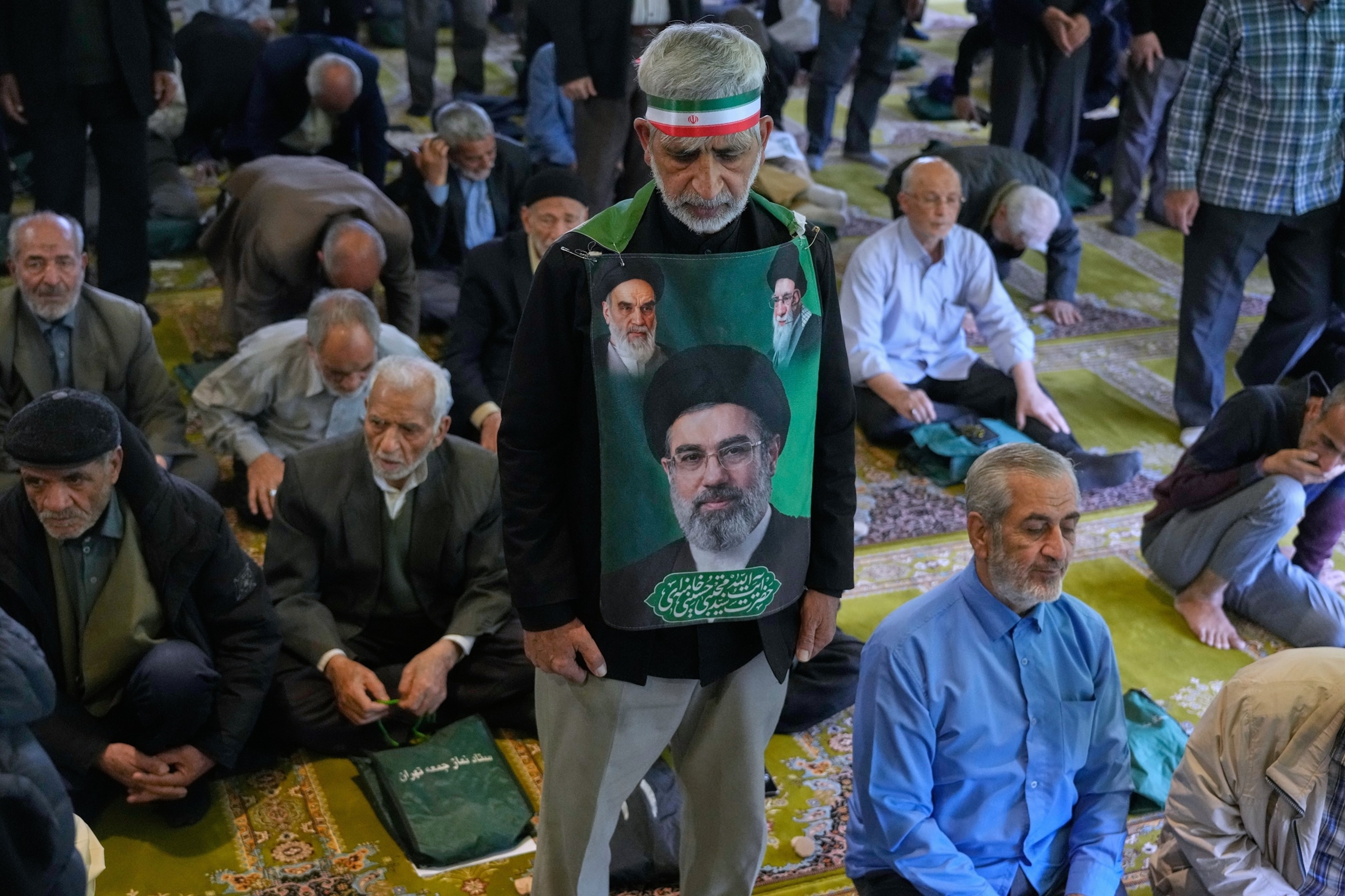 PHOTO: An Iranian worshipper holds a portrait of the Supreme Leader Ayatollah Mojtaba Khamenei, late Supreme Leader Ayatollah Ali Khamenei and the late Ayatollah Khomeini, during Friday prayers at the Tehran University, April 24, 2026.