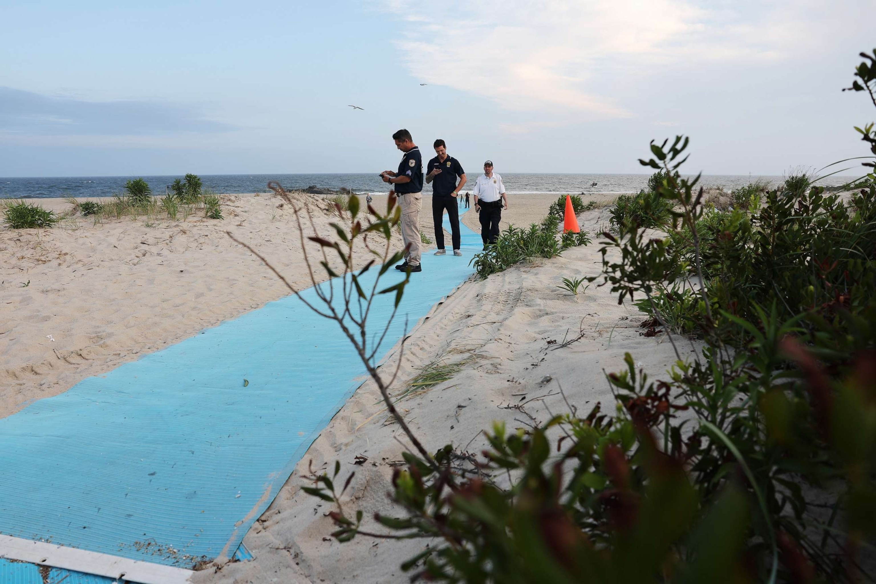 PHOTO: Police gather along Rockaway Beach at 59th Street after a woman was attacked by a shark in the early evening on Aug. 7, 2023 in New York City.