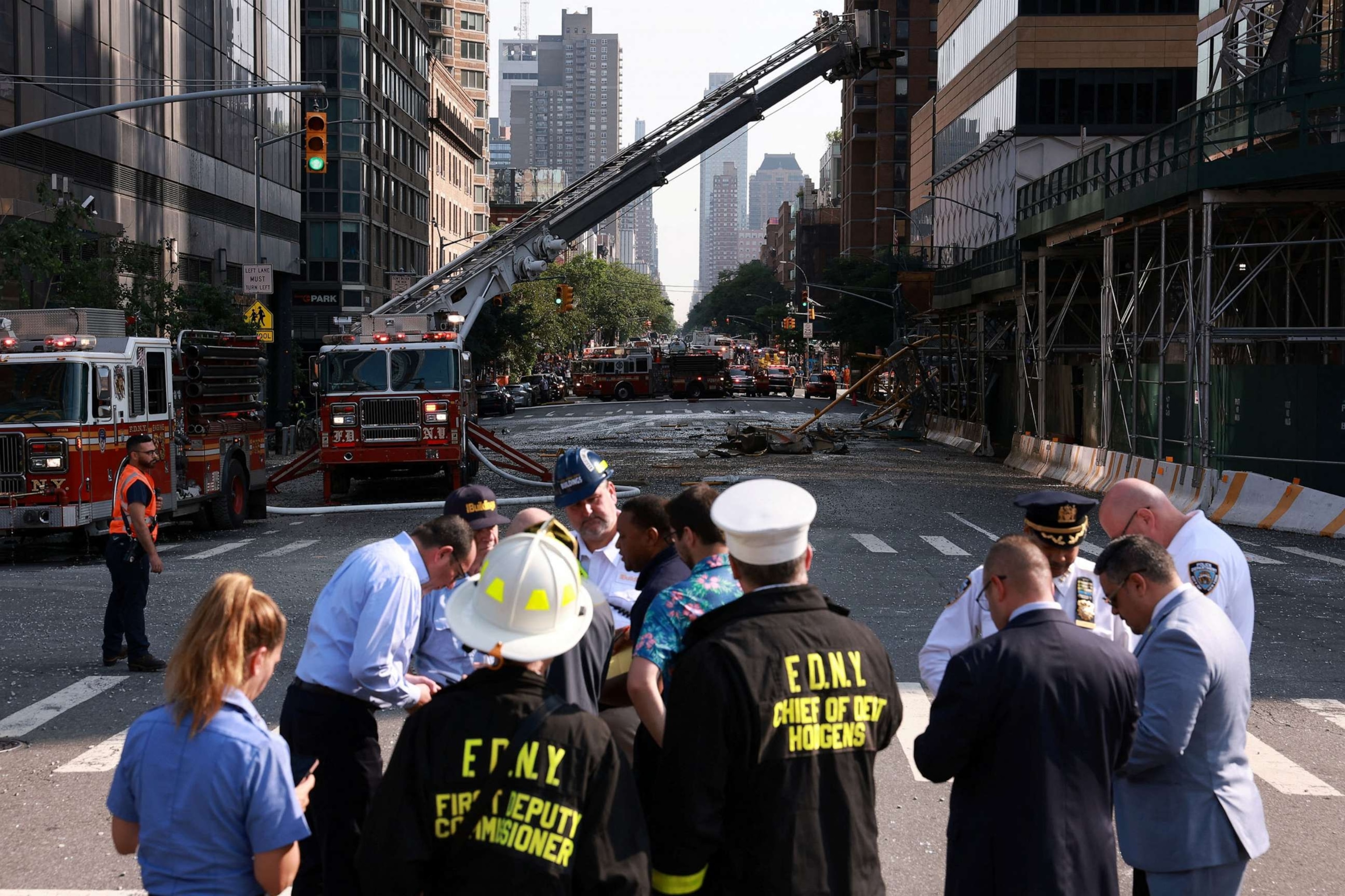 PHOTO: Members of the Fire Department of the City of New York (FDNY) and others gather after a construction crane caught fire on a high-rise building in Manhattan, New York City, July 26, 2023.