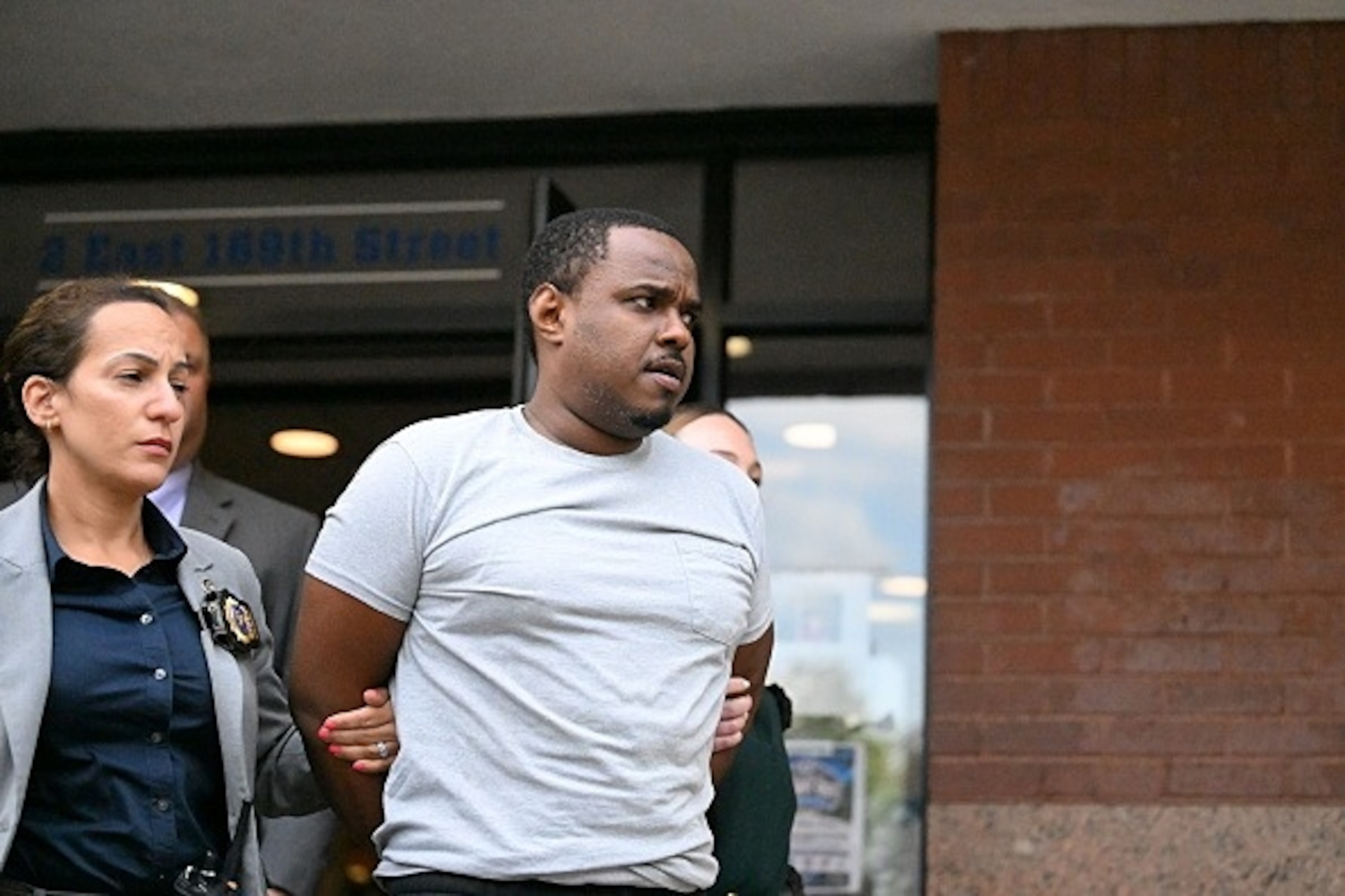PHOTO: New York City detectives escort suspect William Ferrer out of the 42nd Precinct, July 26, 2026, after he was arrested and charged in connection with the fatal shooting of 12-year-old Jacob Freytes. 