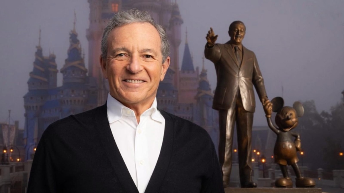 Bob Iger stands in front of Cinderella Castle and the Partners statue at Magic Kingdom
