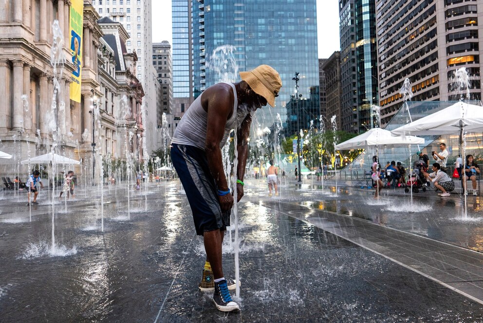 PHOTO: People cool themselves with an ice-cold water bottle from a water station during the Great American State Fair on the National Mall on July 2, 2026, in Washington, D.C.