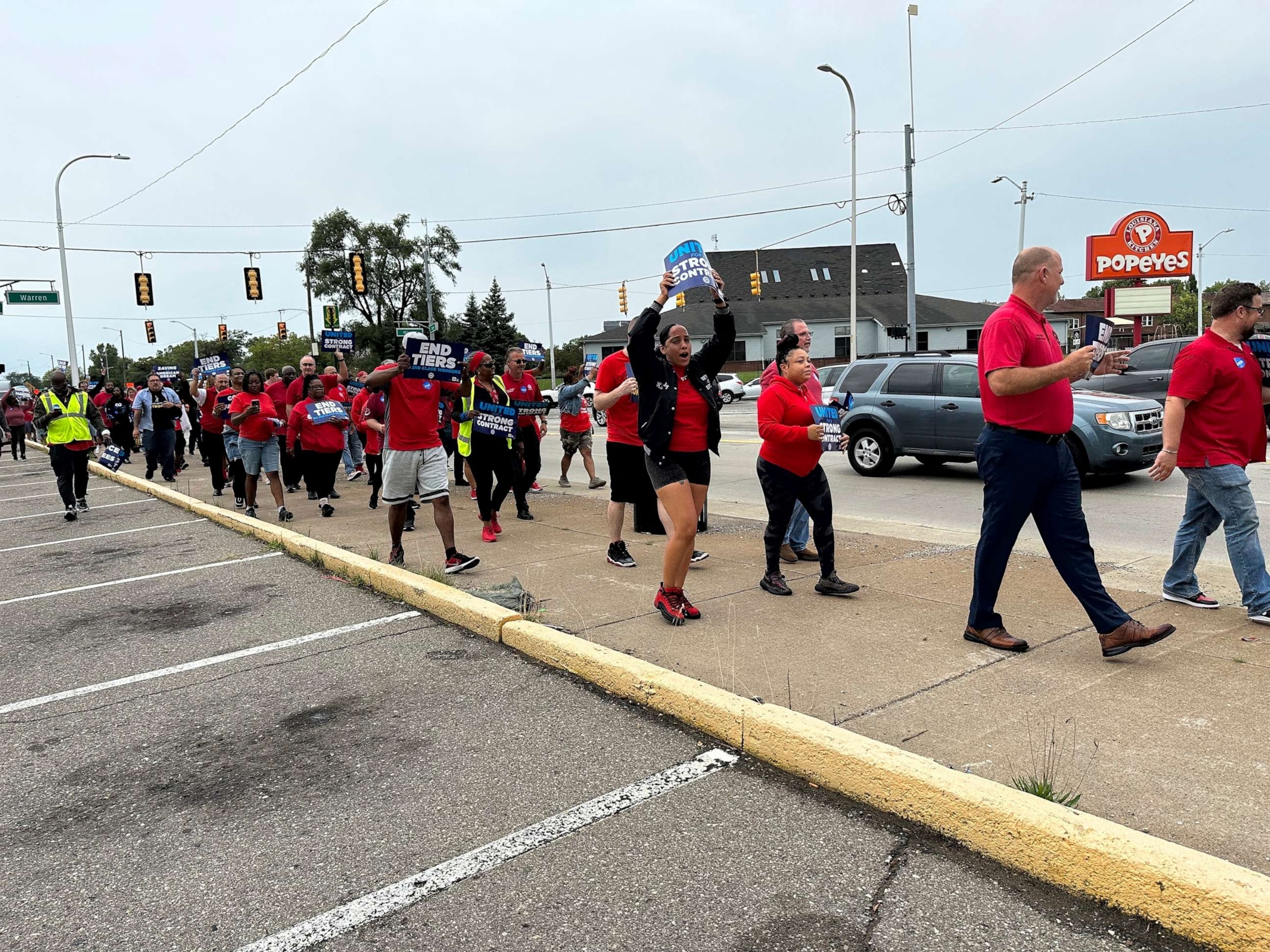 PHOTO: United Auto Workers members march while holding signs at a union rally held near a Stellantis factory on Aug. 23, 2023, in Detroit, Mich.