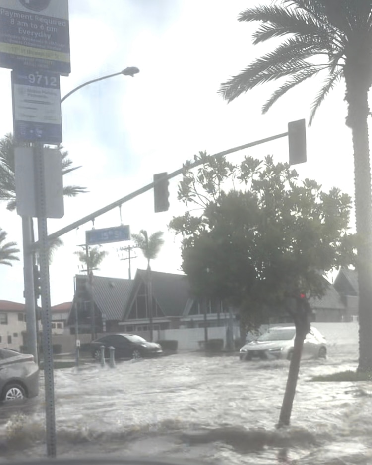 Vehicles traverse a flooded intersection in Newport Beach, California, October 9, 2026. (Audra Giddings)Audra Giddings