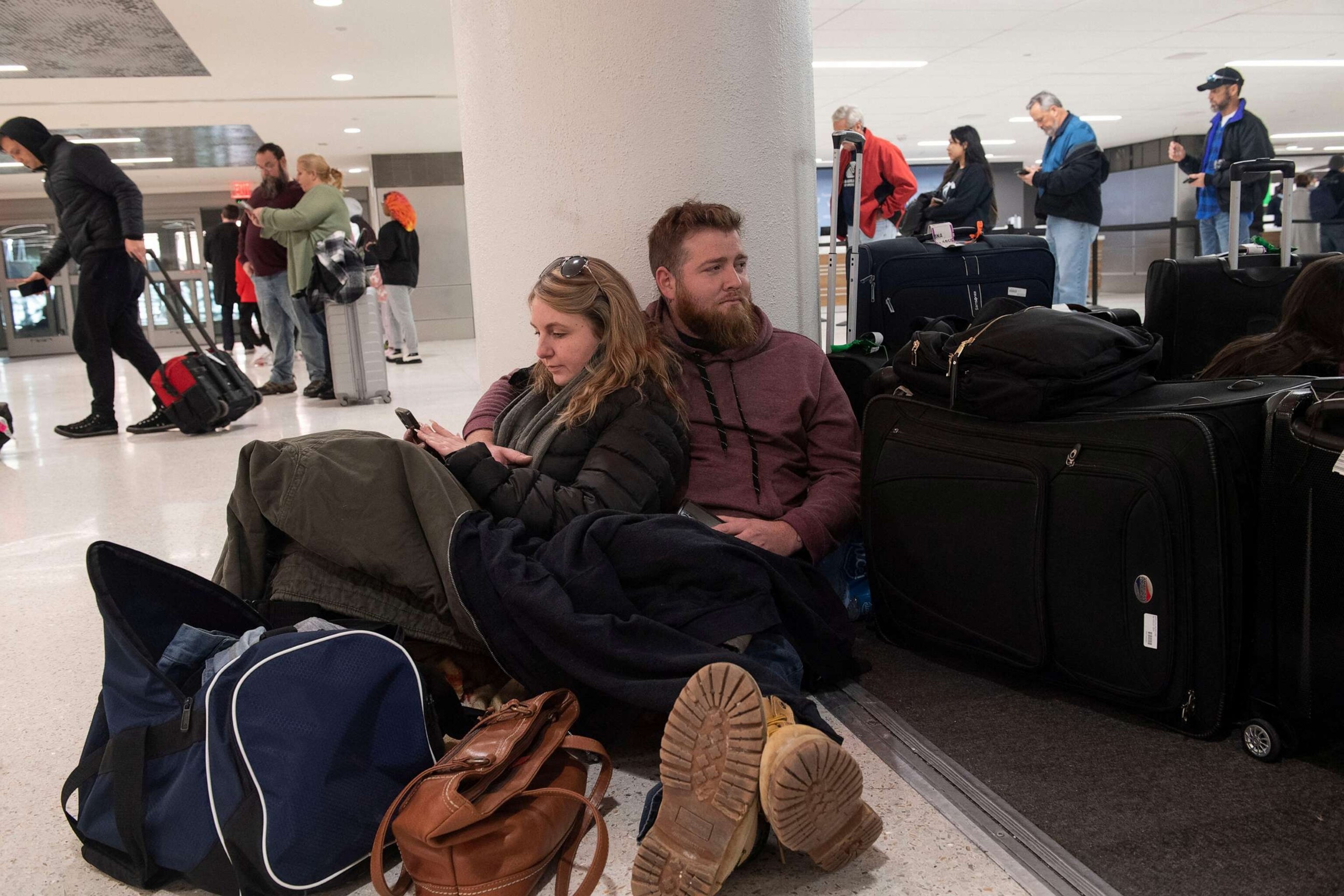 PHOTO: Kelli Jones leans up against James Heyburn of Florida as the two wait for a rental car to be ready after their flight with Southwest Airlines had been canceled at Nashville International Airport in Nashville, Tenn., Dec. 27, 2022.