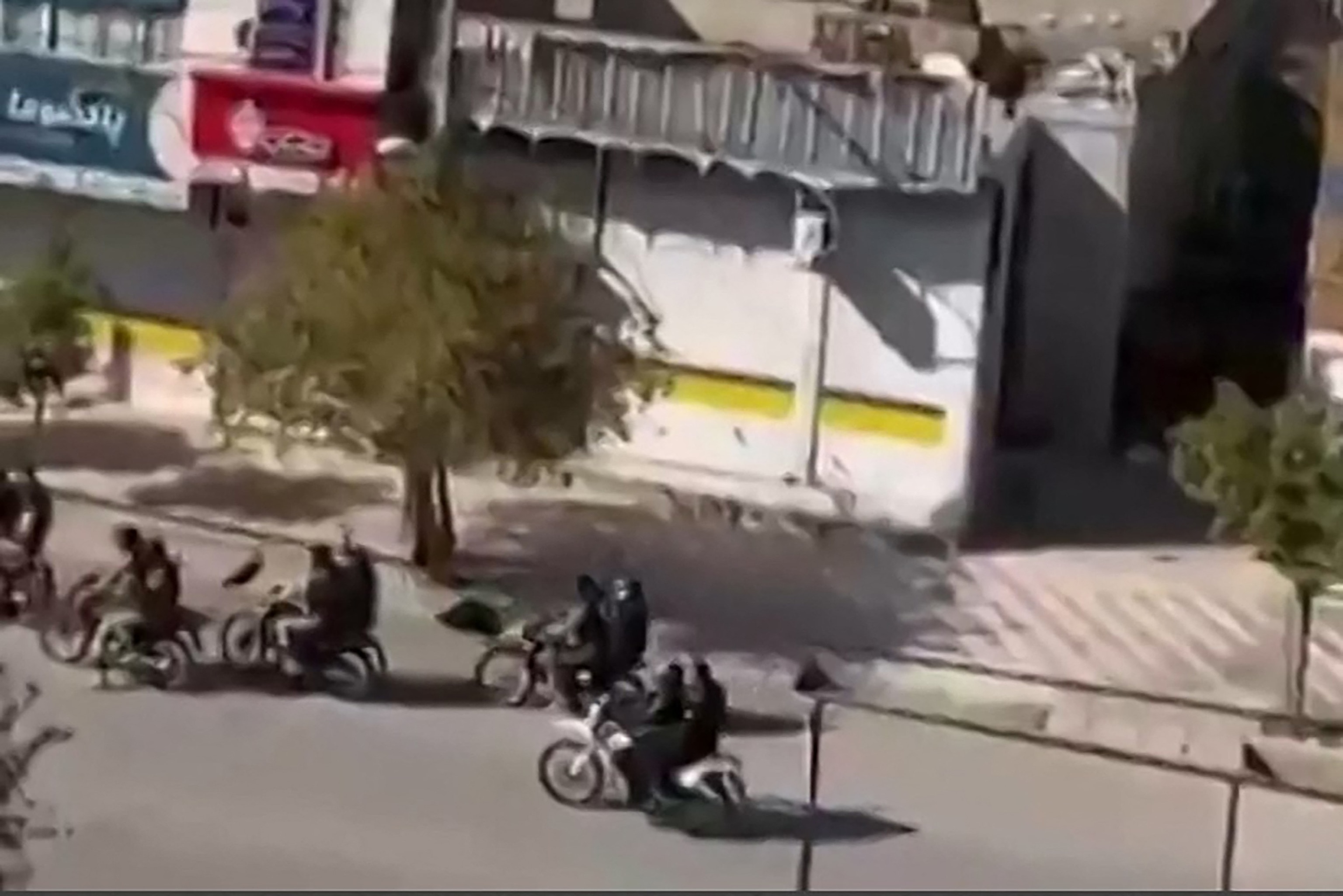 FOTO: Esta captura de video tomada de imágenes de UGC del 11 de enero de 2026 y verificada por equipos de AFPTV en París el 11 de enero muestra a las fuerzas de seguridad armadas iraníes en motocicletas disparando municiones al aire en la calle Hazraty en Kazerun, una ciudad al oeste de Shiraz.