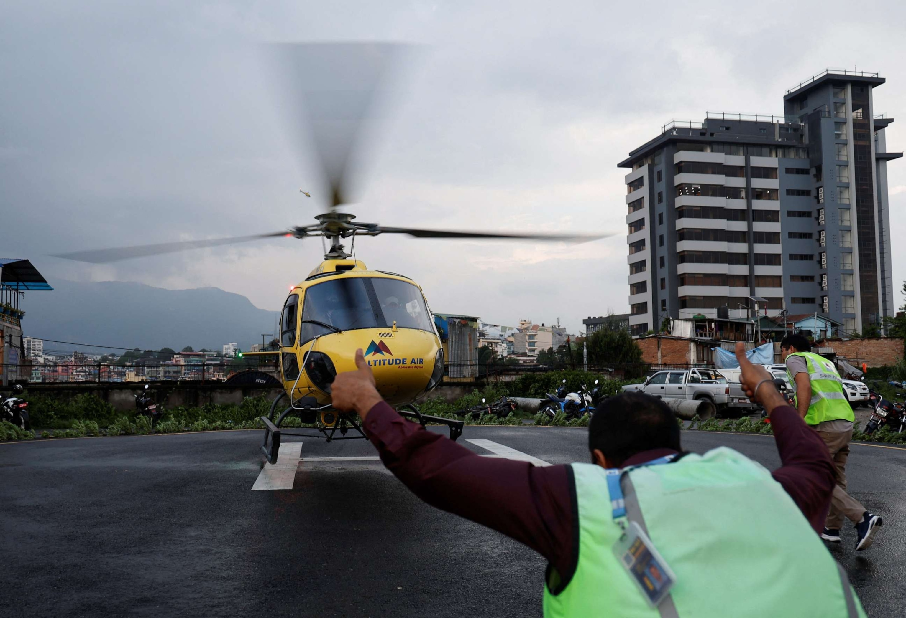 PHOTO: Officials air rush towards the helicopter carrying the body of the victims killed in a helicopter crash, at Tribhuvan University Teaching Hospital in Kathmandu, Nepal, July 11, 2023.