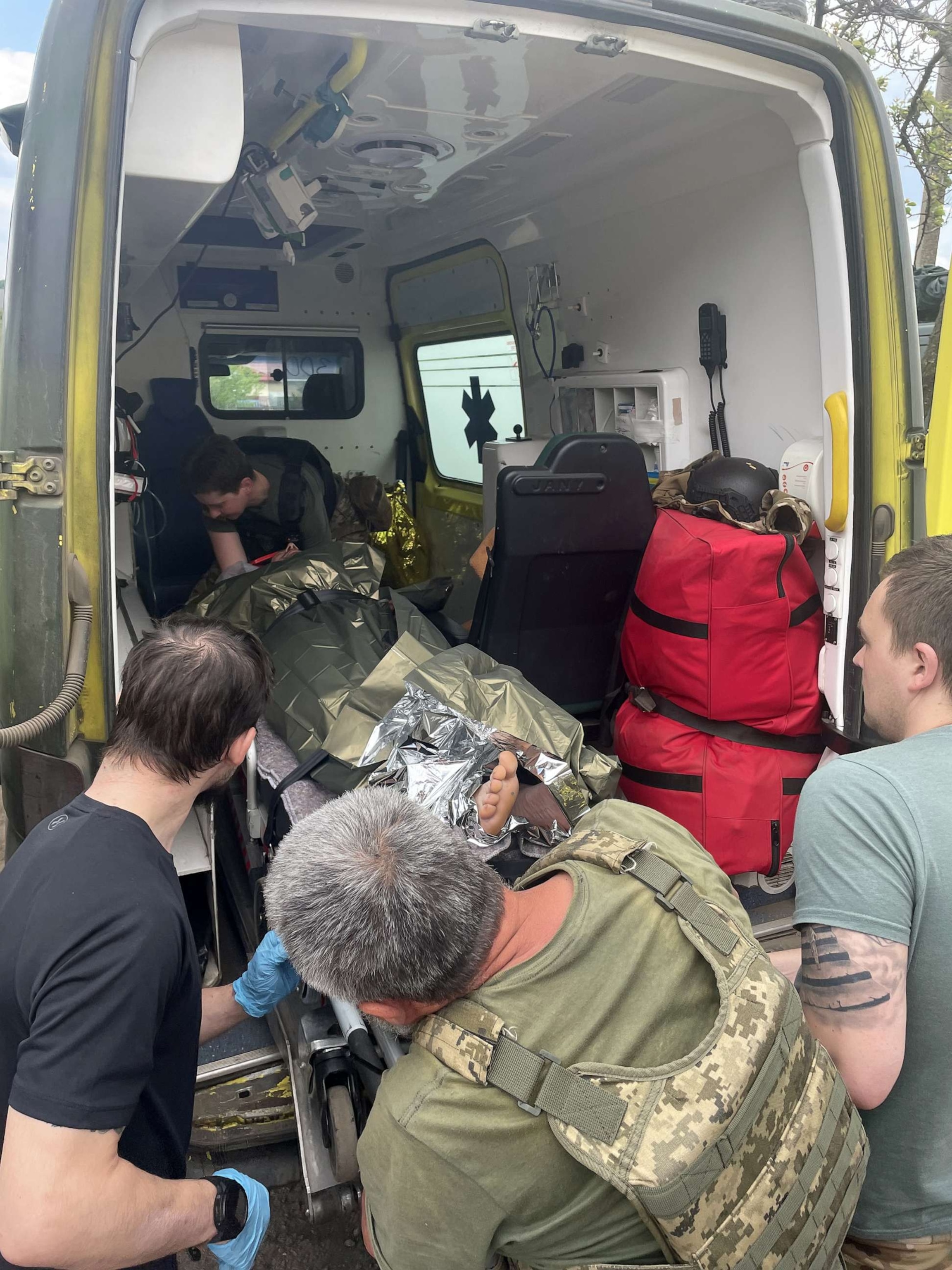 PHOTO: A soldier with heavy shrapnel wound to his leg is loaded into an ambulance before being driven away to a more significant medical facility for further treatment.