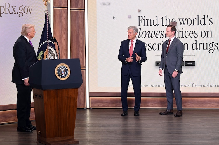 US President Donald Trump (L) listens as the Administrator for the Centers for Medicare & Medicaid Services Mehmet Oz (C) and the chief design officer of the National Design Studio Joe Gebbia introduce the new TrumpRx website, in the South Court Auditorium of the White House in Washington, DC, on February 5, 2026. (Saul Loeb/AFP via Getty Images)