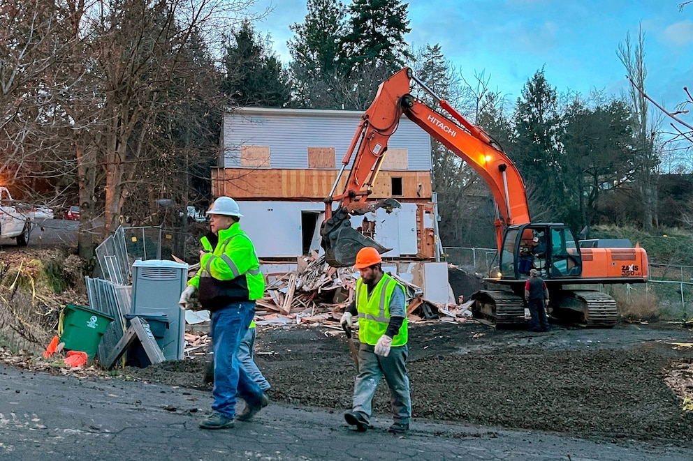 PHOTO: In this Dec. 28, 2023, file photo, workers walk past the demolition of a home in Moscow, Idaho, where four University of Idaho students were killed last year. 