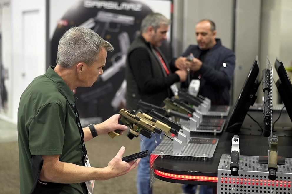 PHOTO: In this Jan. 25, 2024, file photo, people inspect weapons at a trade show in Las Vegas.