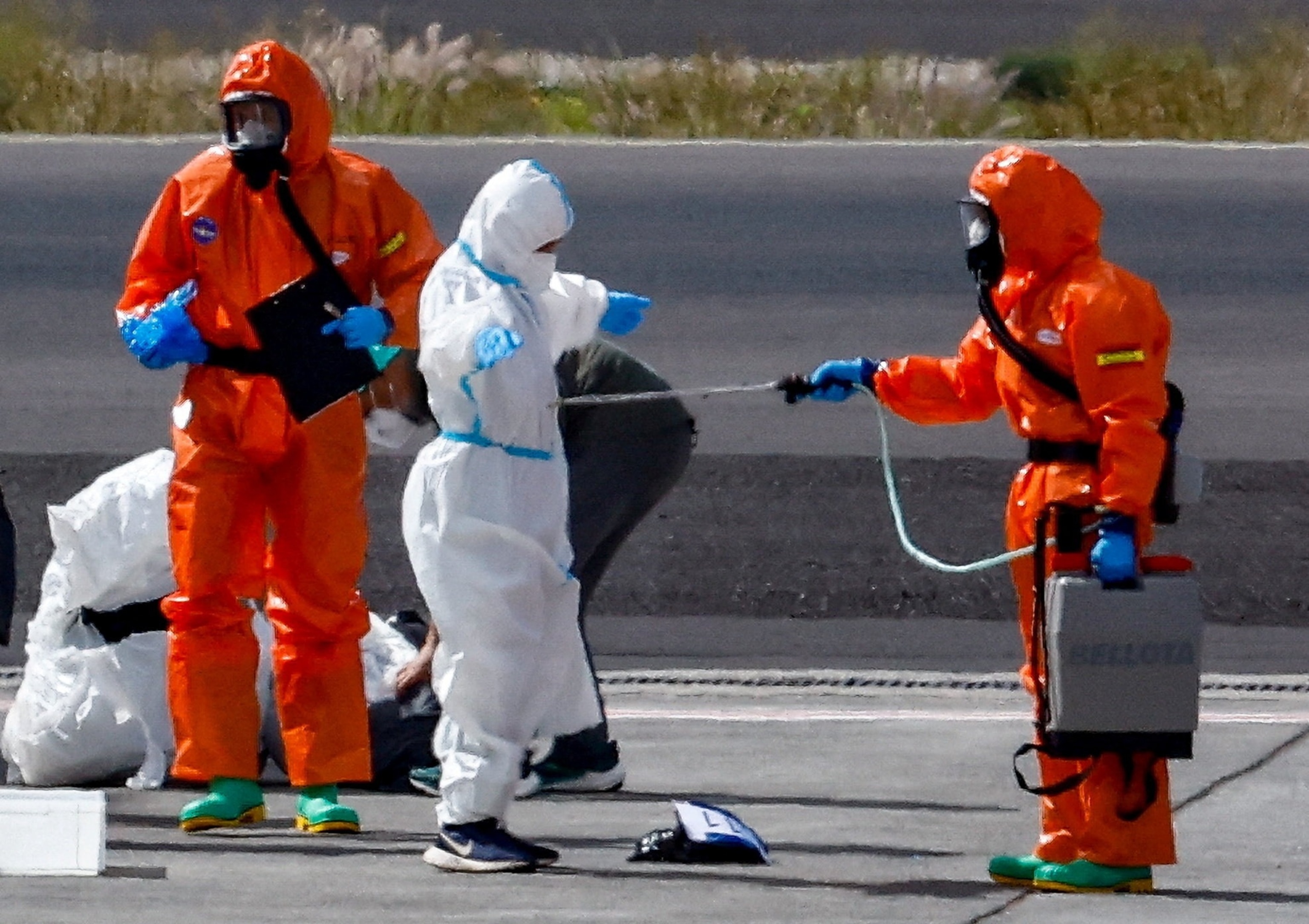 PHOTO: A passenger of the cruise ship MV Hondius, which was affected by a hantavirus outbreak, gets disinfected on the tarmac at Tenerife Sud airport,  Canary Islands, Spain, May 10, 2026.
