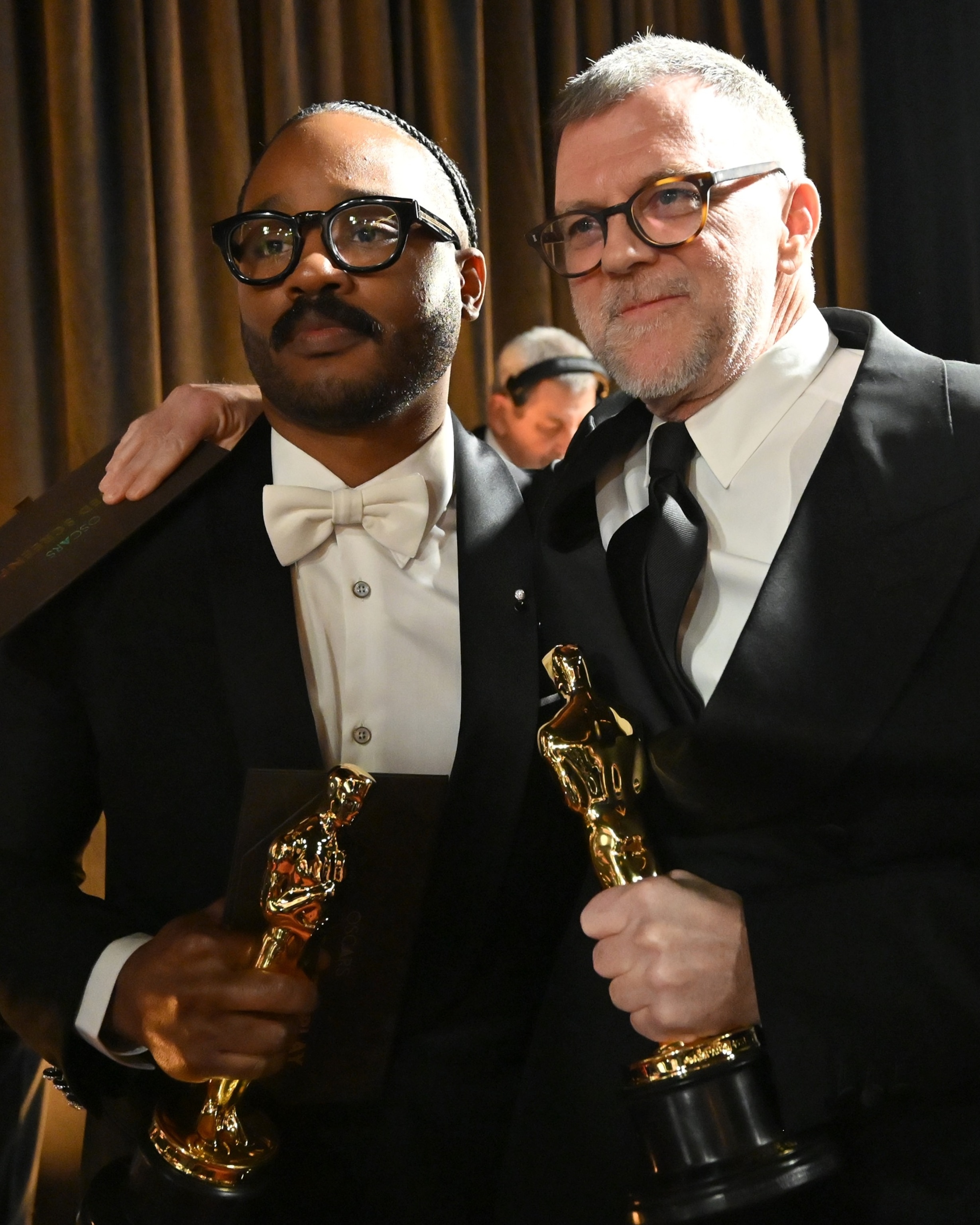 PHOTO: Ryan Coogler, winner of the Original Screenplay award poses with Paul Thomas Anderson, winner of the Writing (Adapted Screenplay) award for "One Battle After Another" backstage at the 98th Academy Awards, March 15, 2026 in Hollywood, Calif.