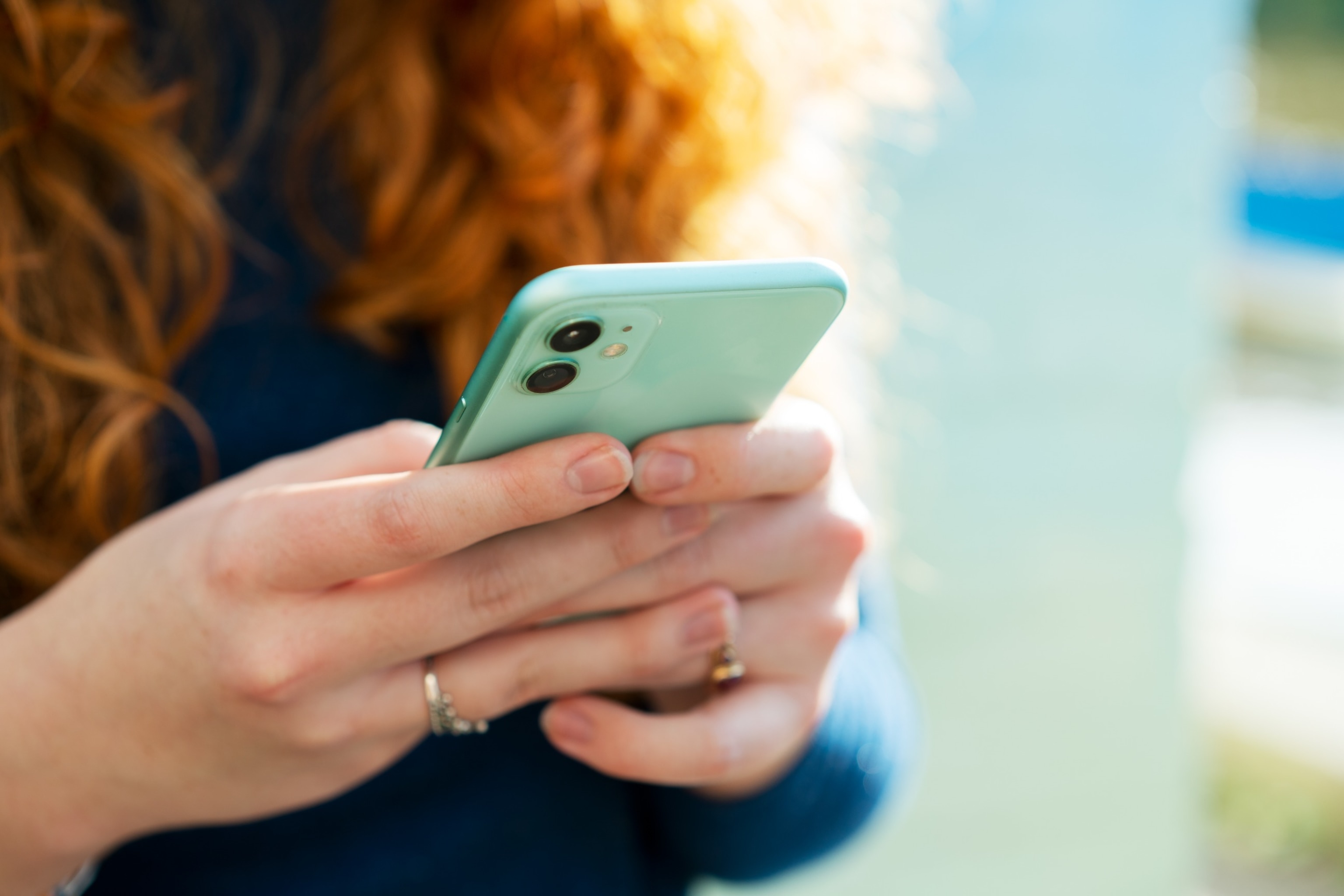 PHOTO: In this undated stock photo, a young woman looks scrolls on her phone.