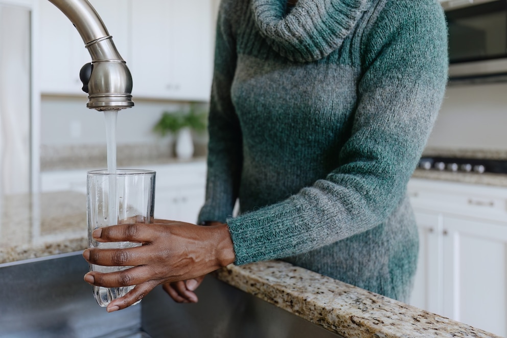 PHOTO: A person fills a glass of water from a tap.
