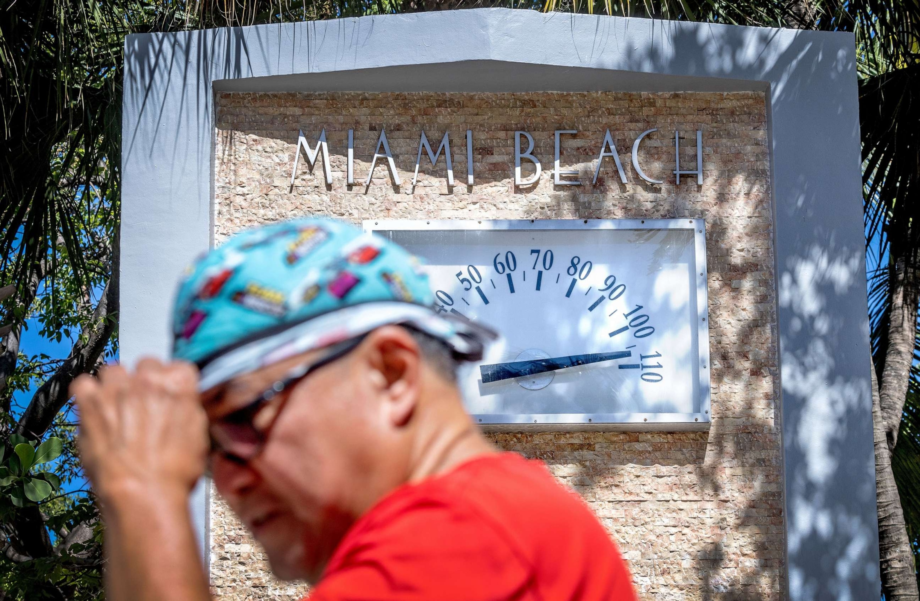 PHOTO: A person walks in front of a Miami Beach Clock Thermometer that marks the temperature at 105 degrees Fahrenheit (about 40 Celsius) during the hottest summer in modern history, in Miami Beach, Fla., on July 30, 2023.