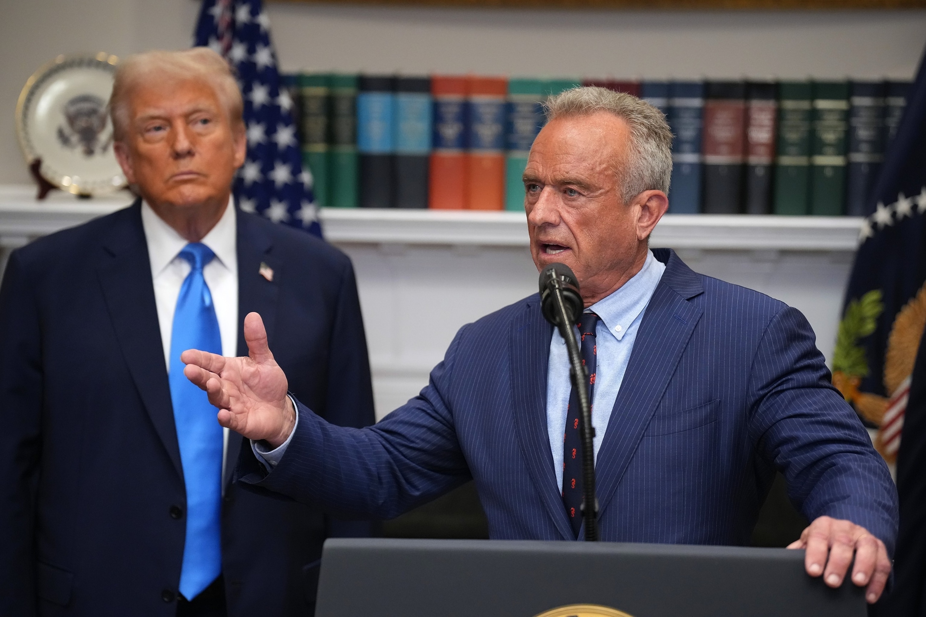 FOTO: El presidente Donald Trump escucha mientras el secretario de Salud y Servicios Humanos, Robert F. Kennedy Jr., responde preguntas después de hacer un anuncio sobre los hallazgos médicos y científicos sobre las causas del autismo en los niños, el 22 de septiembre de 2025 en Washington.