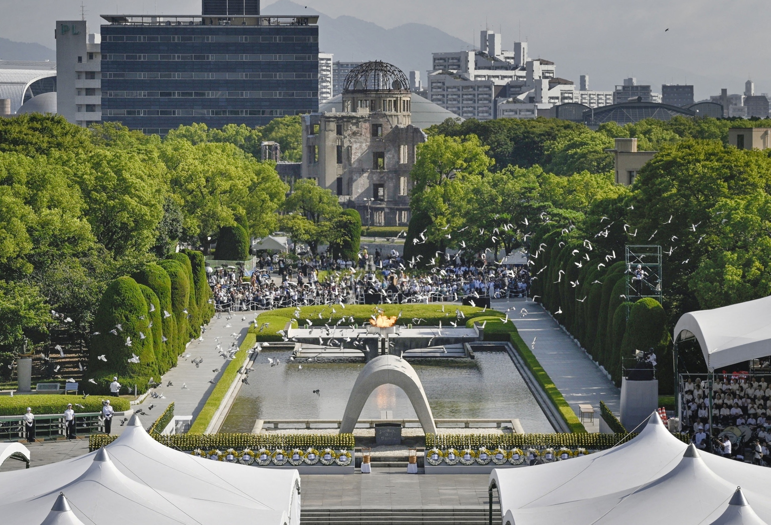 PHOTO: Doves fly over the Peace Memorial Park with a view of the gutted Atomic Bomb Dome at a ceremony in Hiroshima