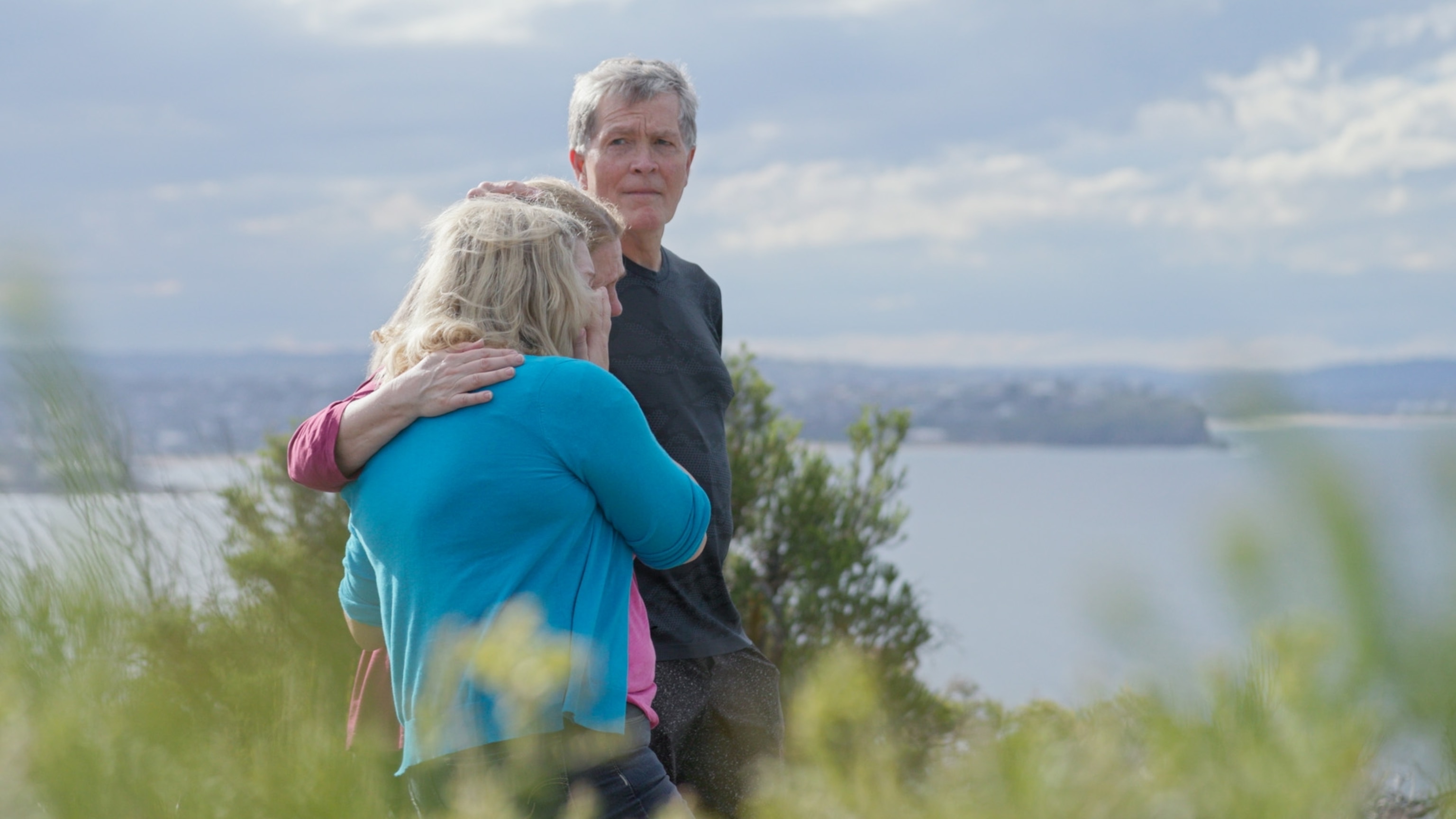 PHOTO: Steve Johnson hugs sisters Terry and Becca Johnson at the top of North Head at the rock where Scott fell.