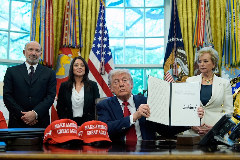 PHOTO: President Donald Trump holds an executive order relating to education in the Oval Office of the White House, April 23, 2025, in Washington.