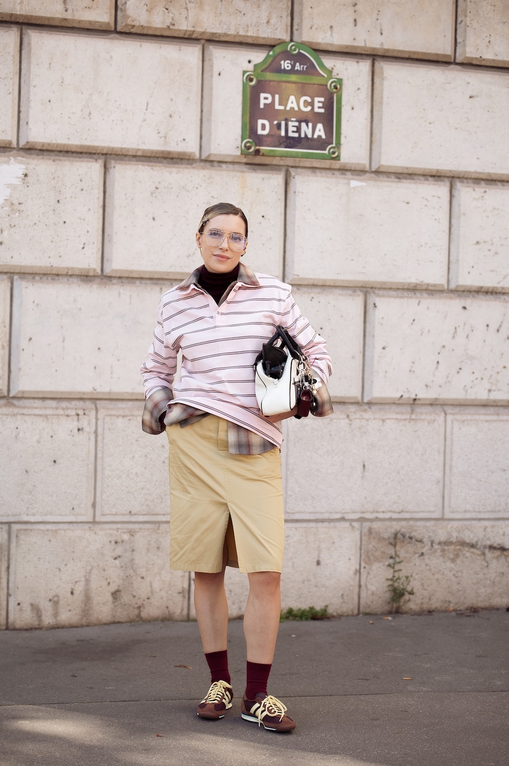 PHOTO: Olga Naumova wears beige pencil skirt with a split, pale pink striped long sleeve shirt, burgundy socks, brown sneakers during Womenswear Spring/Summer 2025 as part of Paris Fashion Week, Oct. 1, 2024, in Paris.