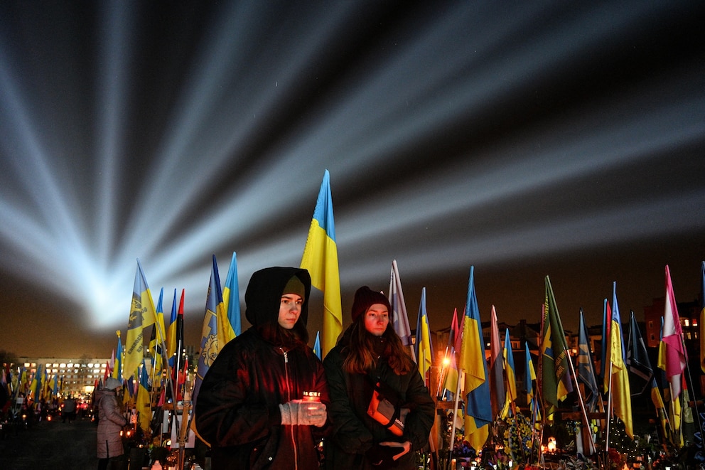 PHOTO: A symbolic illumination called "Rays of Memory" is seen over the graves of Ukrainian soldiers, who died in the war with Russia, as people visit the Lychakiv Military Cemetery in Lviv on Feb. 23, 2025.